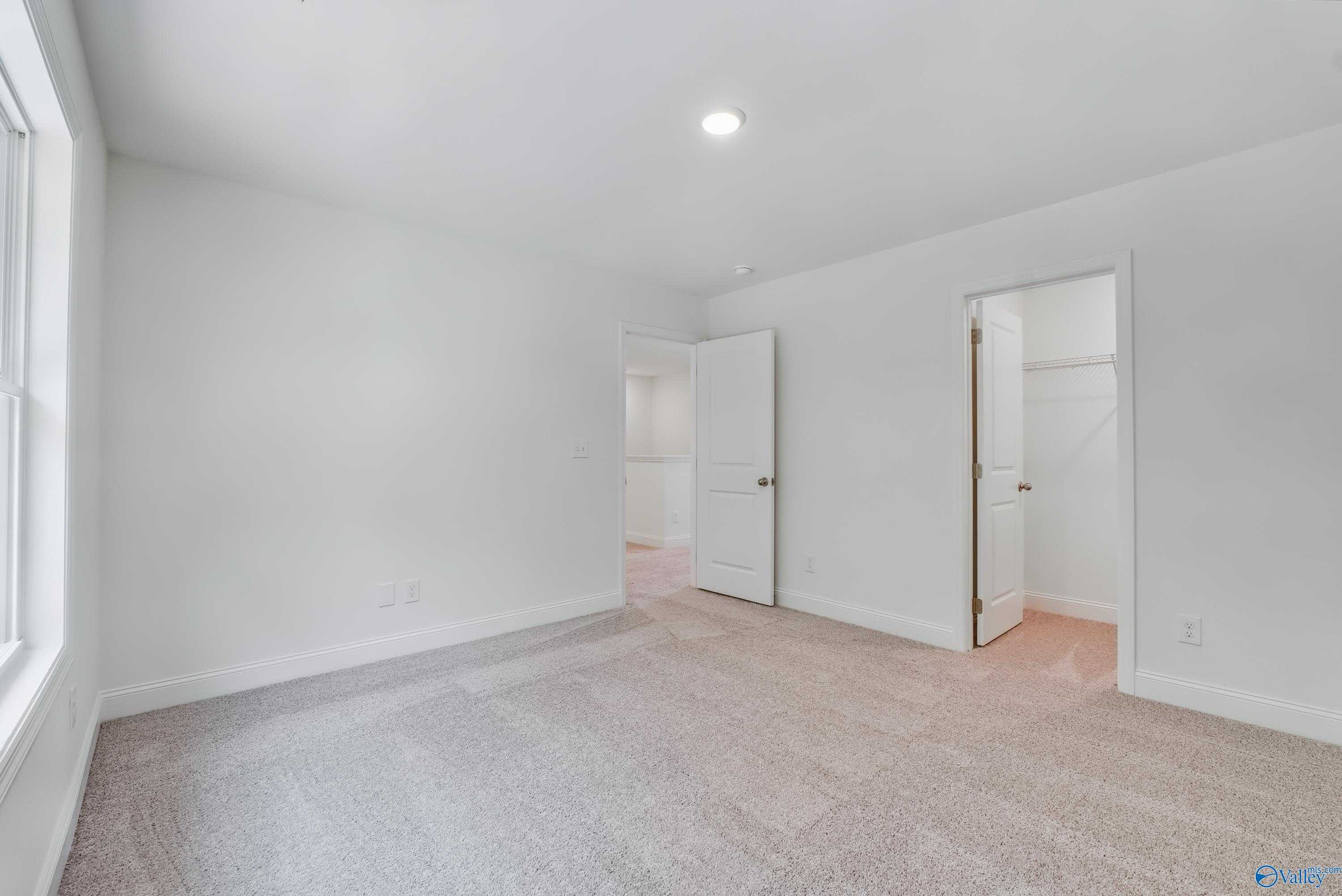 Spacious secondary bedroom with closet and bath access, white walls, carpet in Davidson Homes The Shelby A, Arab, AL