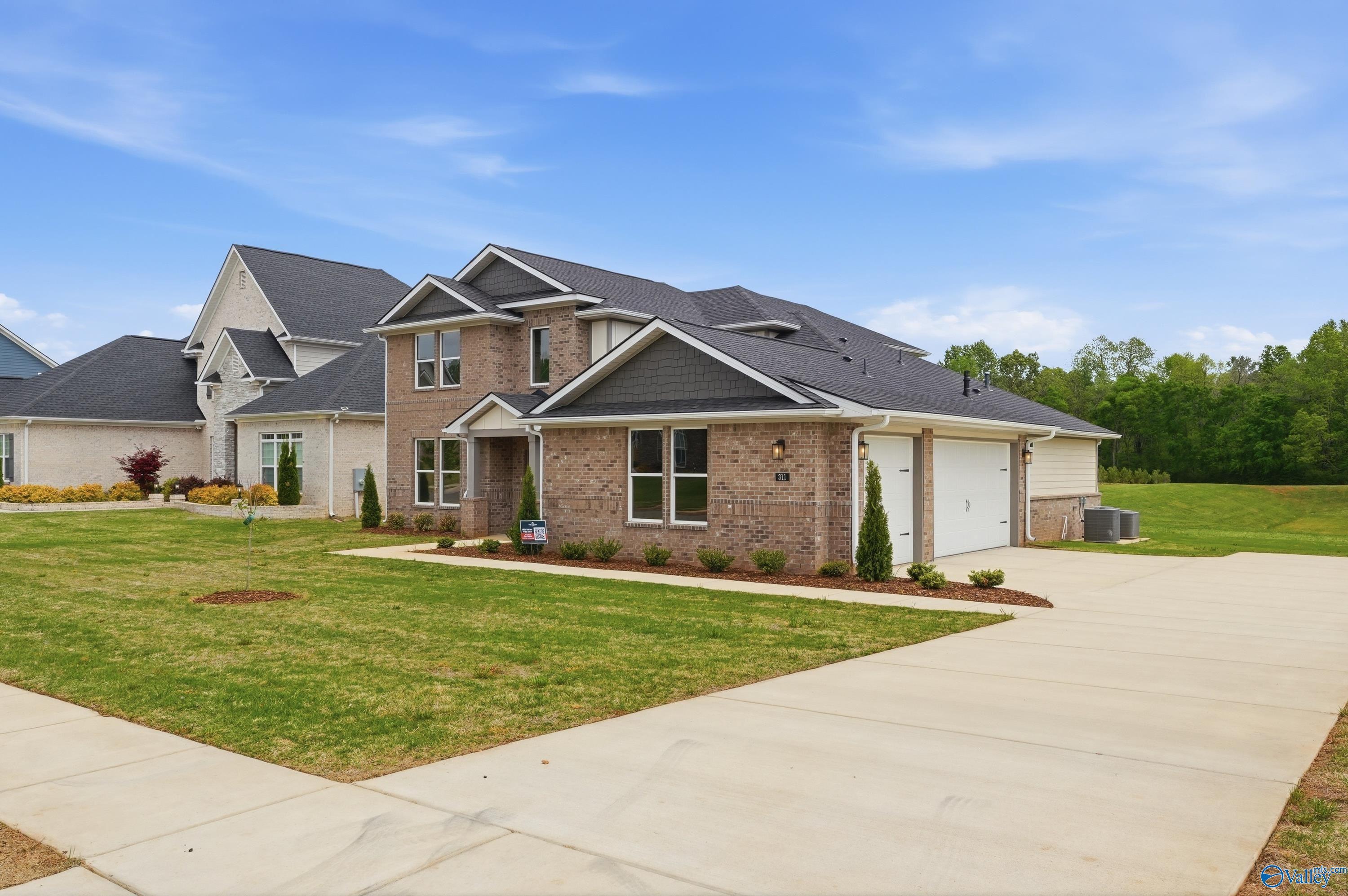 Two-story brick home with 3-car garage, driveway, and lush lawn in Riverton Preserve, Huntsville, Alabama - Davidson Homes The Dorado