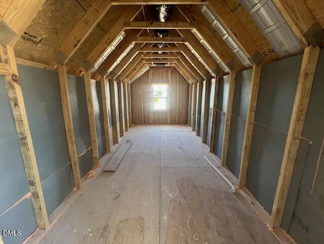 Unfinished attic storage space with exposed wooden trusses and natural light in Davidson Homes The Ash C plan, Lillington NC