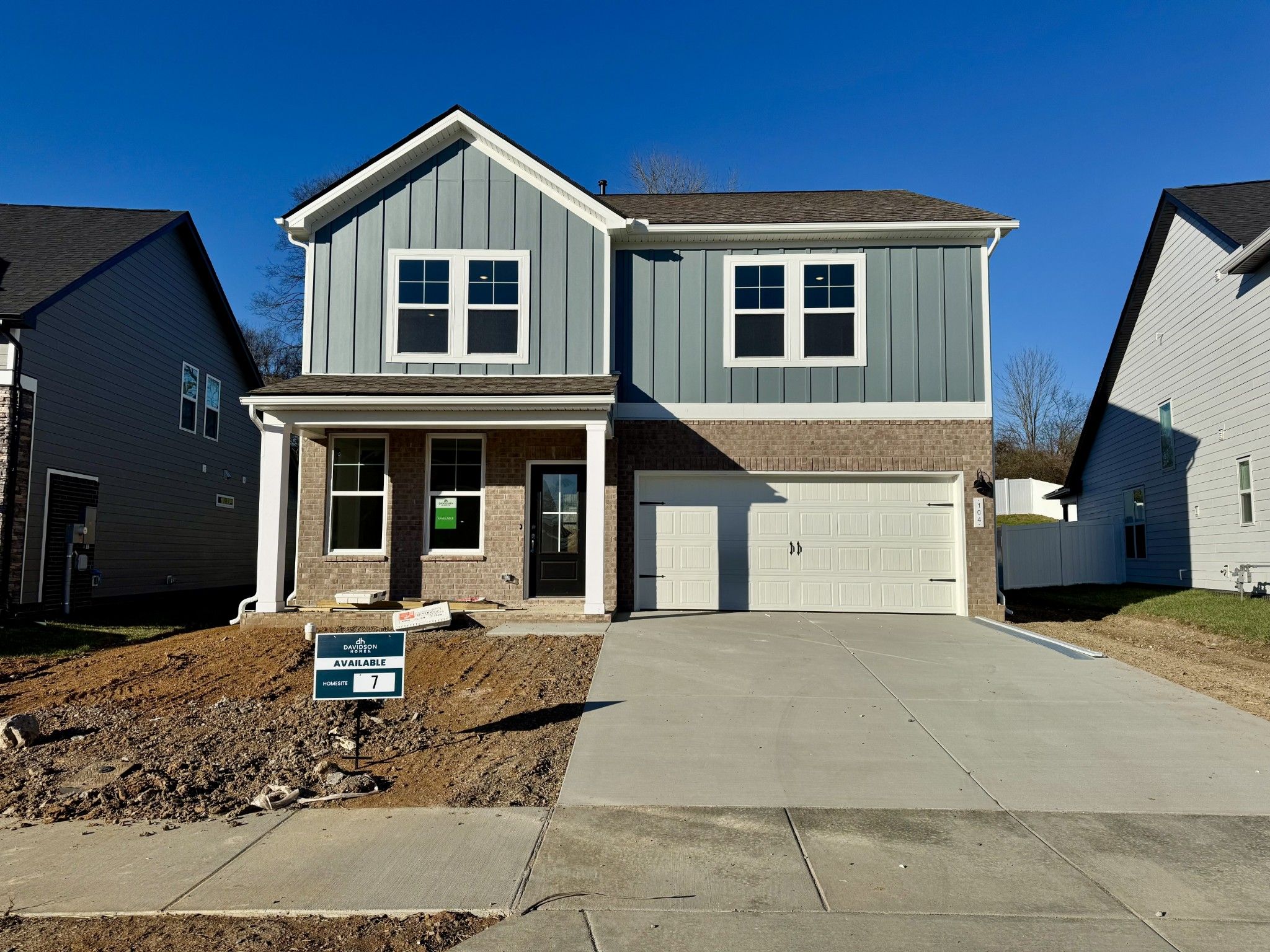 Light blue two-story home with brick accents, 2-car garage, and front porch in Woods Crossing, Gallatin, Tennessee - Davidson Homes The Logan C