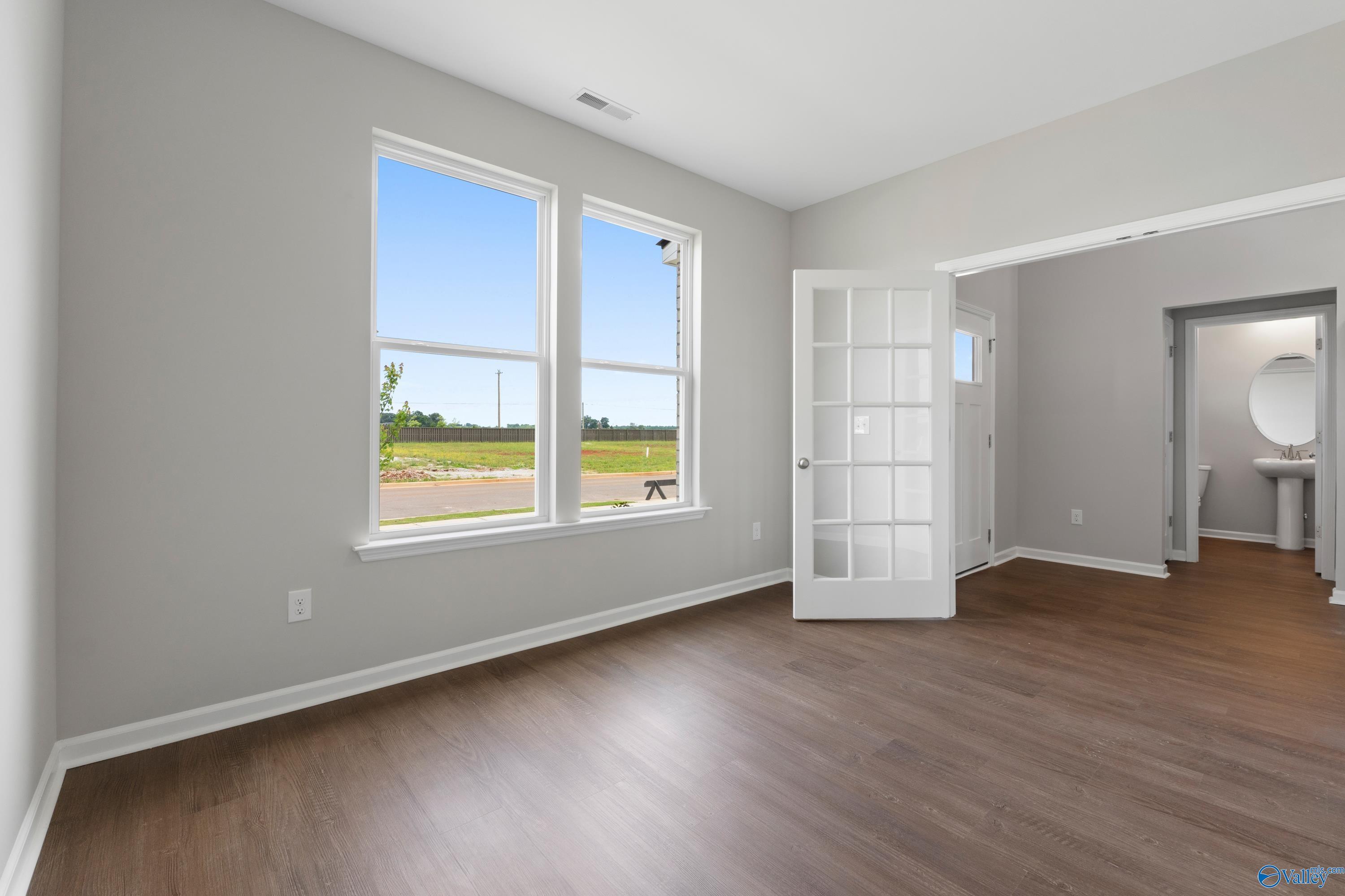 Bright bedroom with large windows overlooking fields, open French doors to en-suite bath in Davidson Homes The Dorado, Athens AL