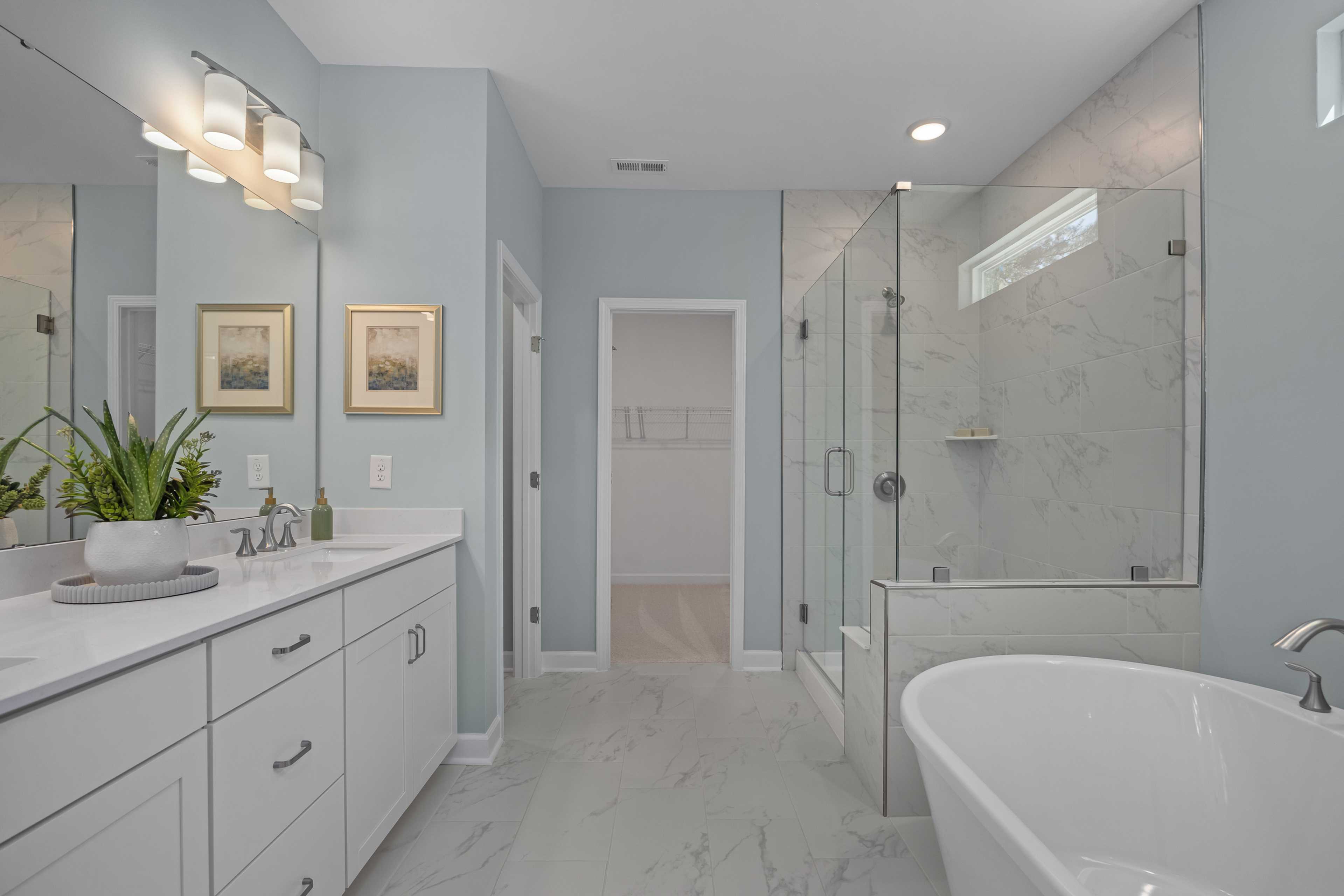 Spacious primary bathroom at Sage on North Main in Wake Forest NC with freestanding tub, glass shower, double vanity