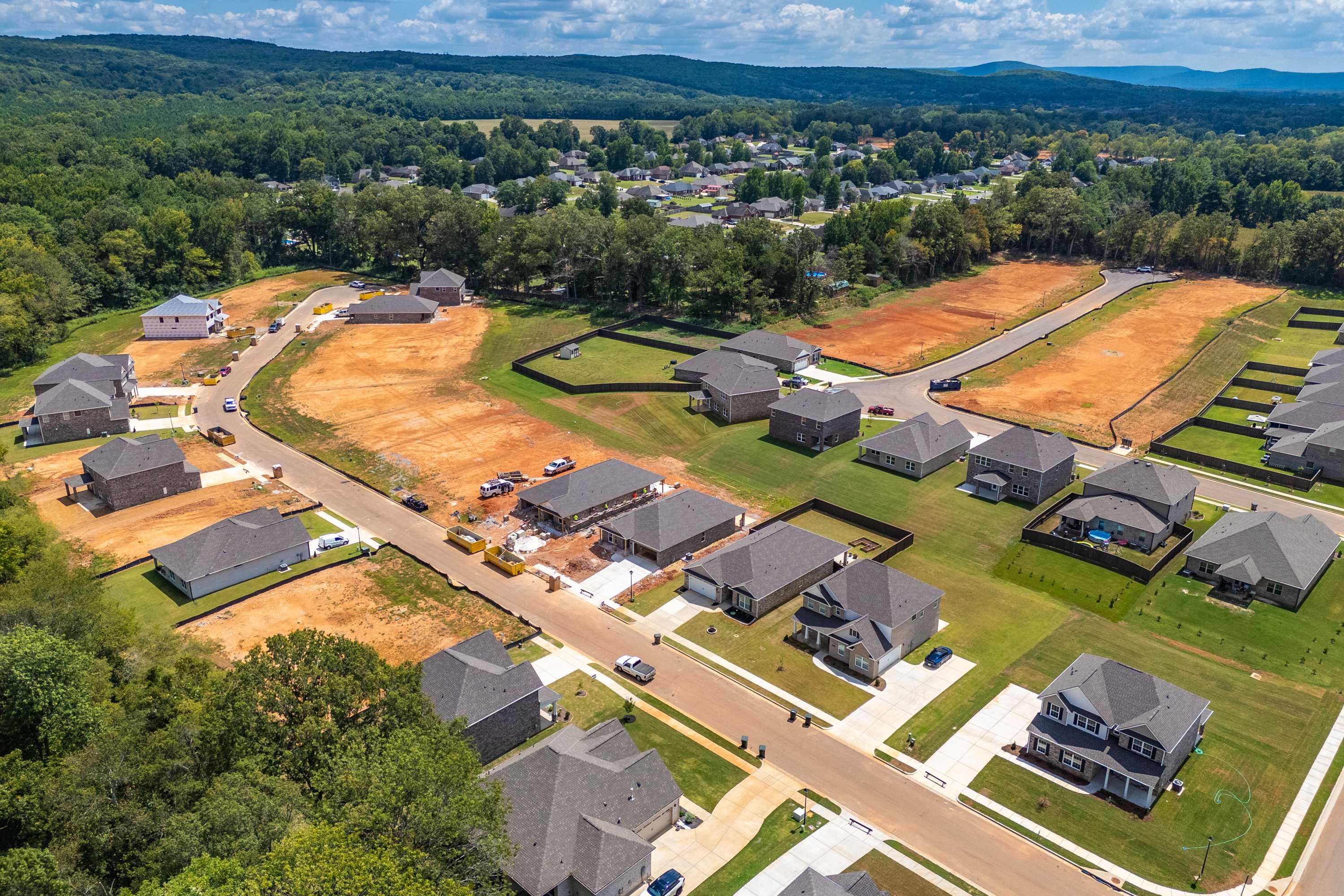 Aerial view of new homes under construction at Creek Grove in New Market, Alabama by Davidson Homes amid forested hills
