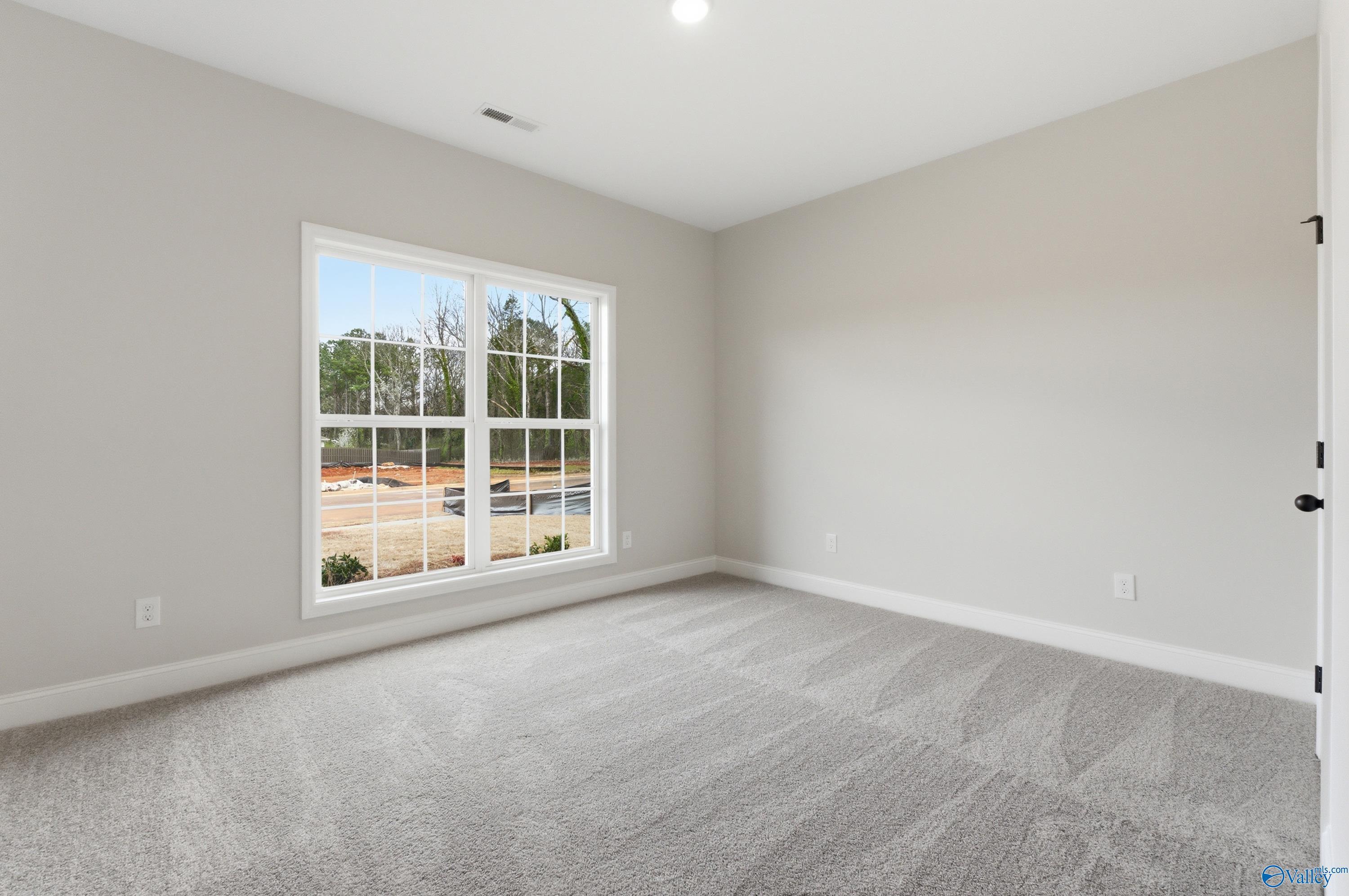 Bright secondary bedroom with large window view of wooded lot in Davidson Homes The Daphne C, Huntsville, Alabama
