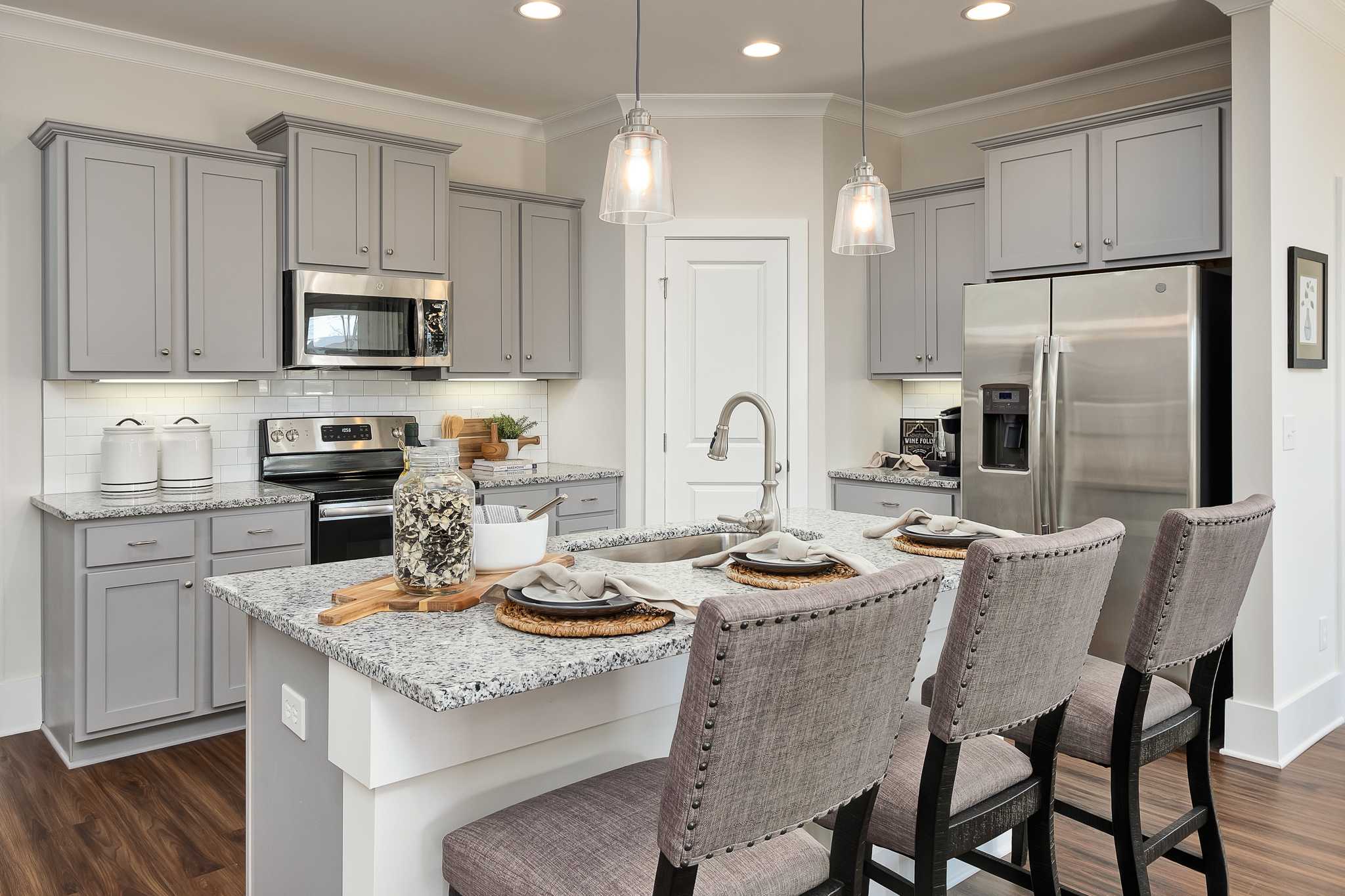 gray kitchen cabinets at the center of the kitchen in The Daphne in Magnolia Preserve