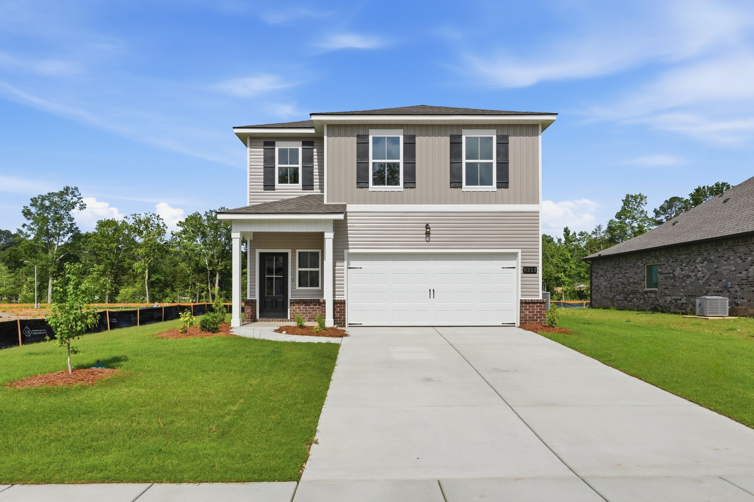 The Russell A two-story single-family home in New Market featuring a two-car garage, brick accents, and modern siding.