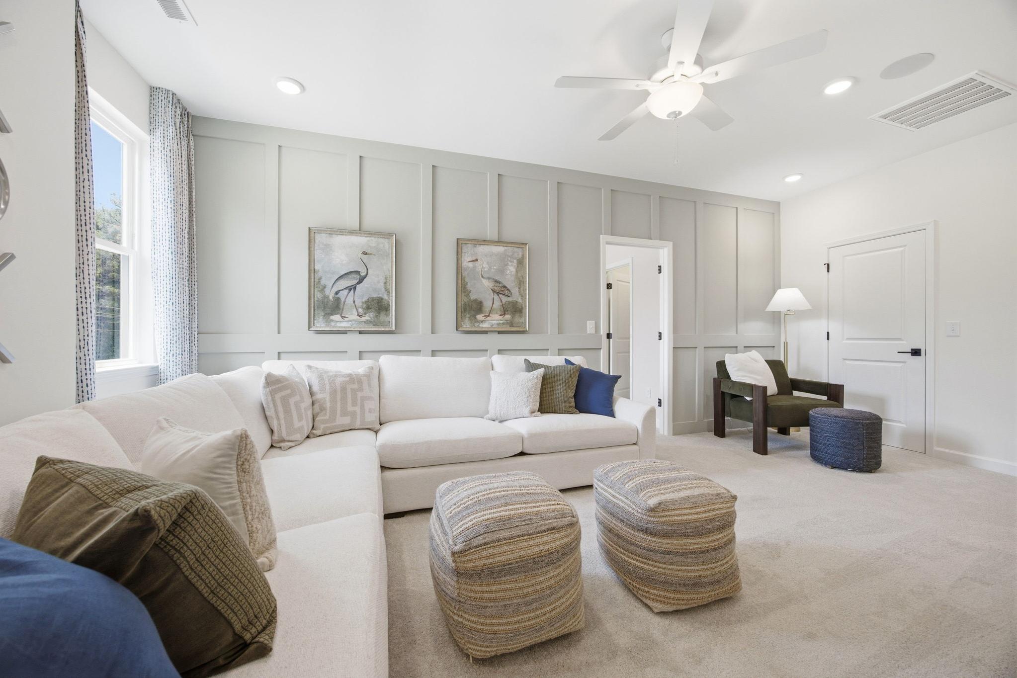 Cozy living room with white L-shaped sectional, gray shiplap walls, heron art at Sage on North Main, Wake Forest NC