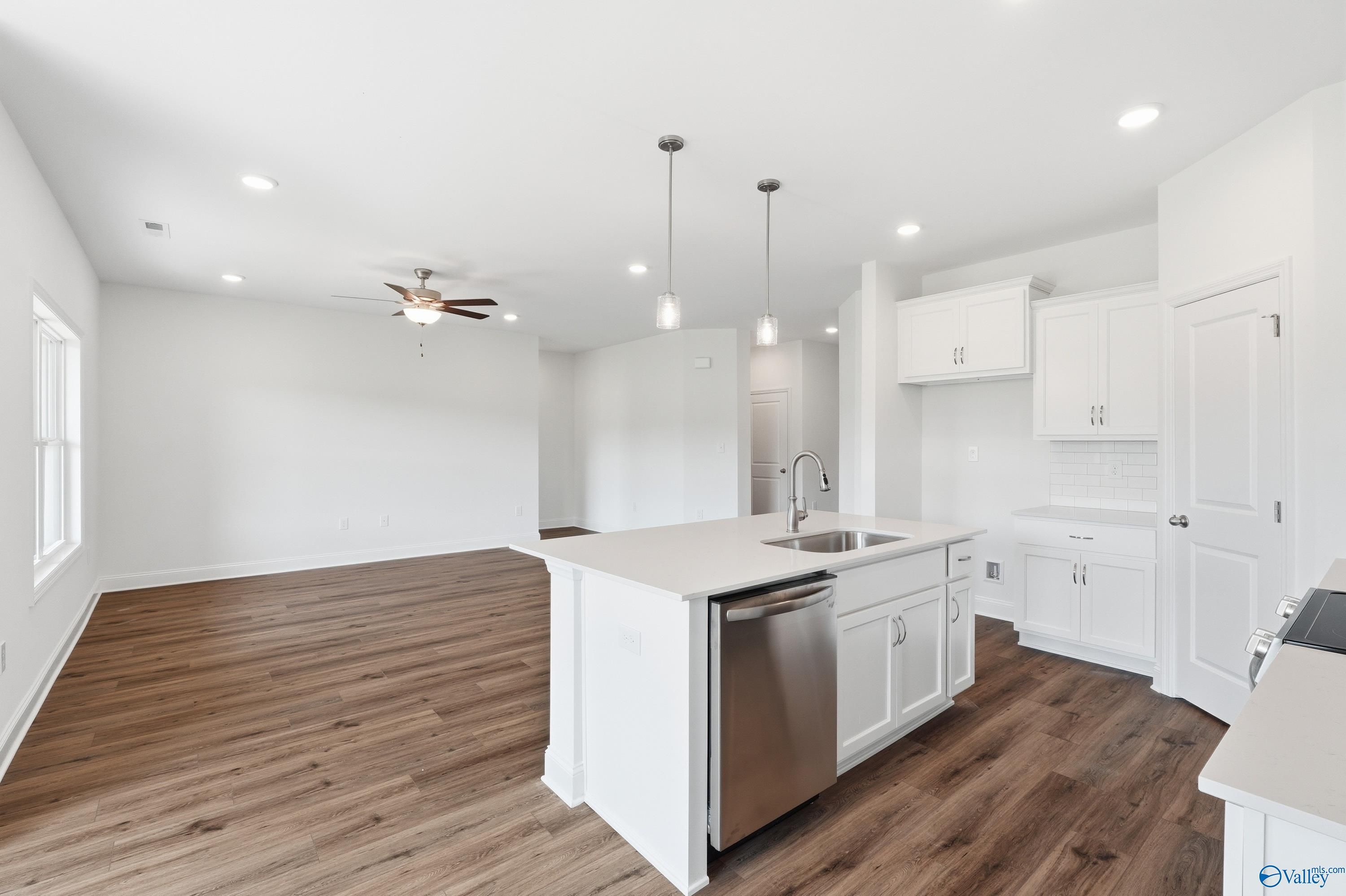 Open-concept kitchen and living area with white cabinets in The Asheville floor plan at Jaguar Hills, Huntsville, Alabama.