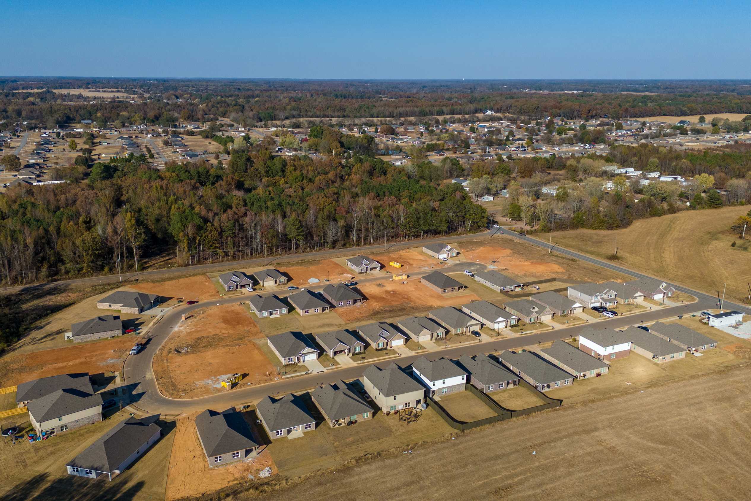 Aerial view of new single-family homes under construction in Mallard Landing, Athens Alabama with wooded fields