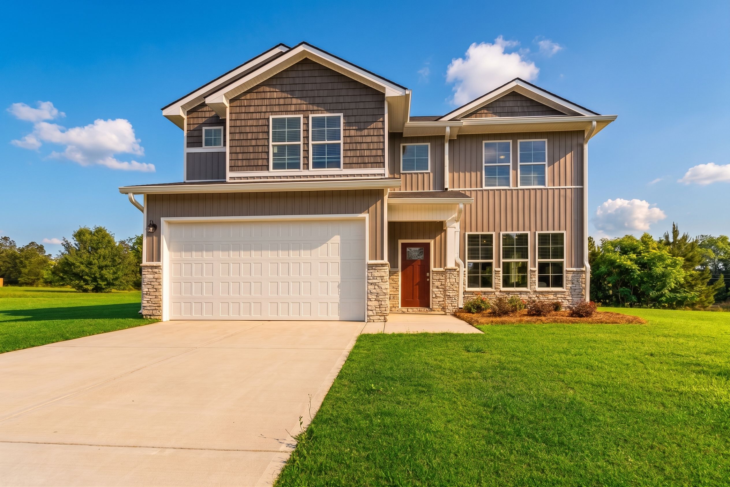 Modern two-story home exterior in Ivy Glen Perry GA by Evermore Homes with gray siding red door attached garage and manicured lawn