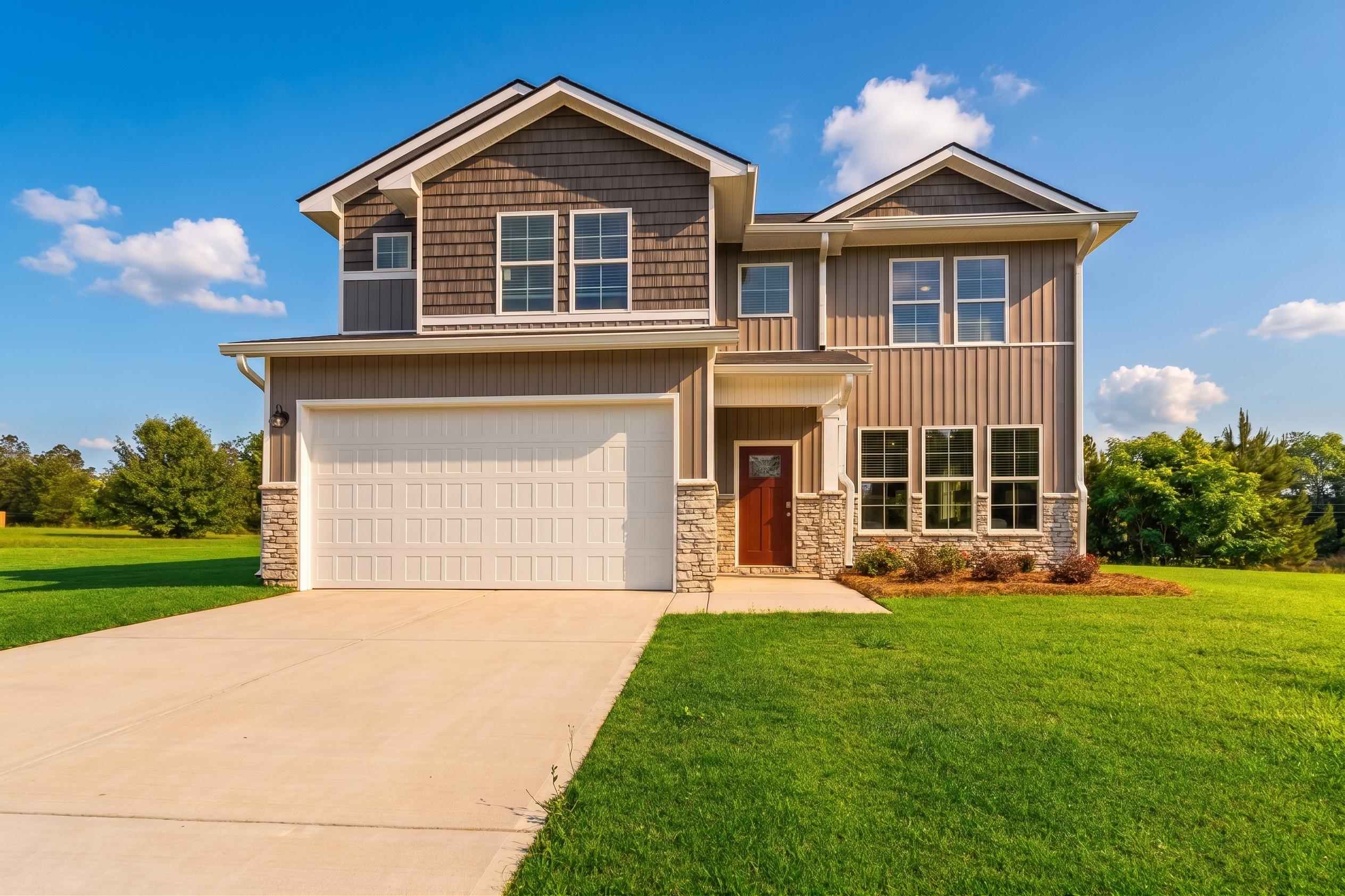 Modern two-story home exterior in Ivy Glen Perry GA by Evermore Homes with gray siding red door attached garage and manicured lawn