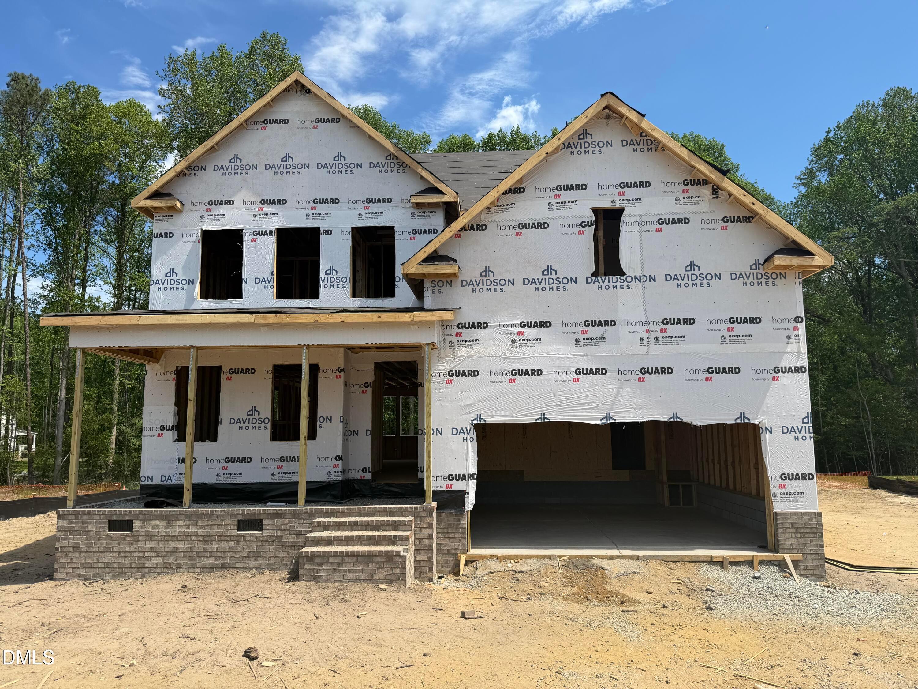 Two-story Davidson Homes Hickory II C under construction in Wellers Knoll, Lillington, NC, with front porch and open 2-car garage