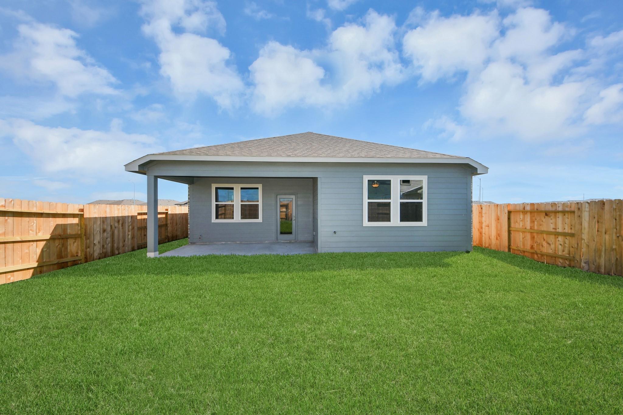 Covered patio and private backyard of The Riviera A floor plan by Davidson Homes in Emberly, Beasley, Texas.