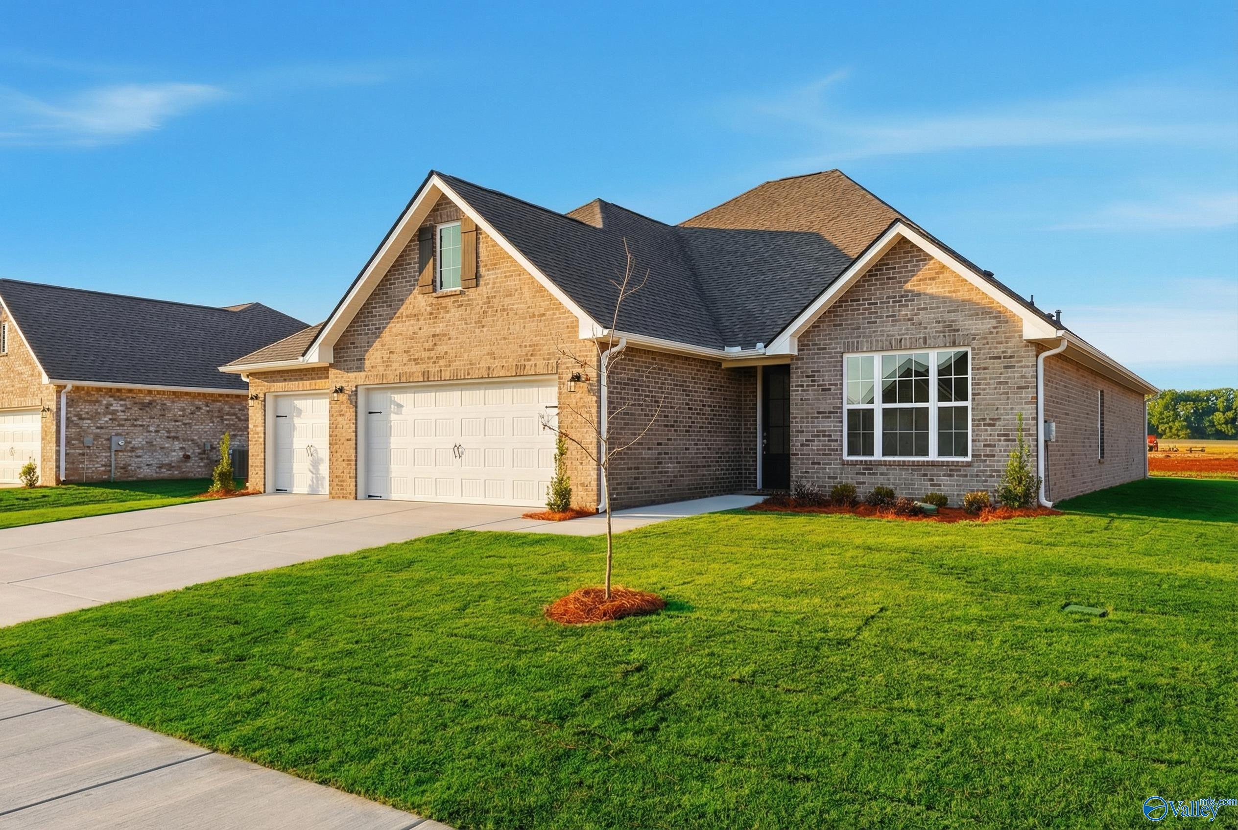 Brick single-story The Lanier home with 3-car garage, driveway, and lush lawn in Pikes Ridge, Meridianville, Alabama