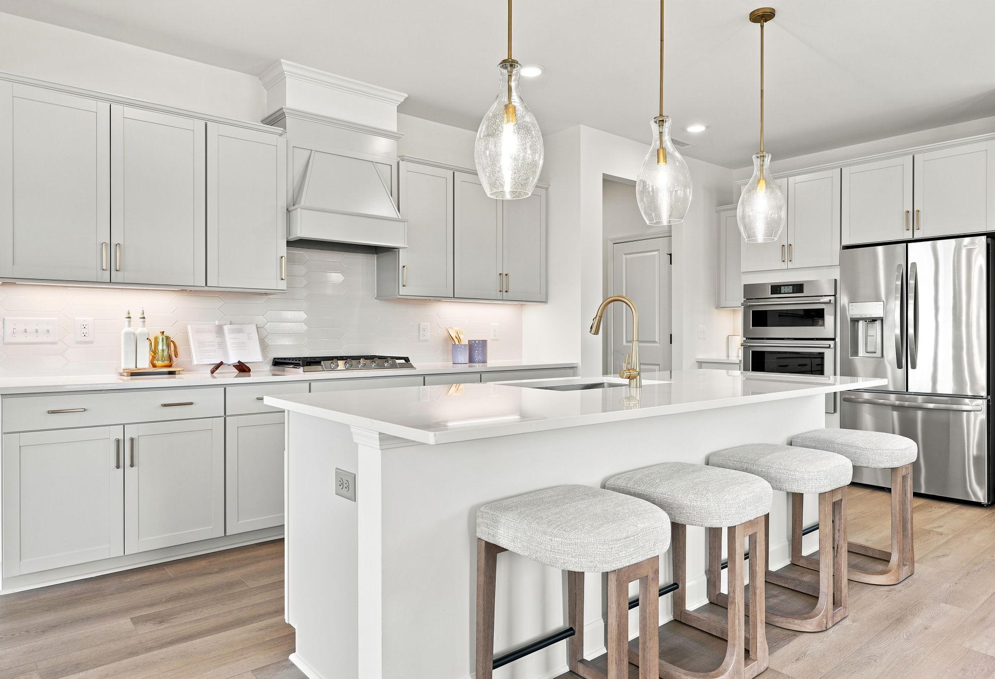 Modern gourmet kitchen in The Beech by Davidson Homes featuring a spacious island, pendant lighting, and stainless steel.
