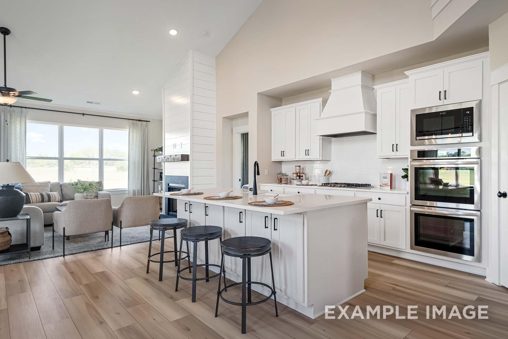 Modern open-concept kitchen with white shaker cabinets, stainless steel appliances, and breakfast island in Davidson Homes The Ridgeport C, Gallatin, TN