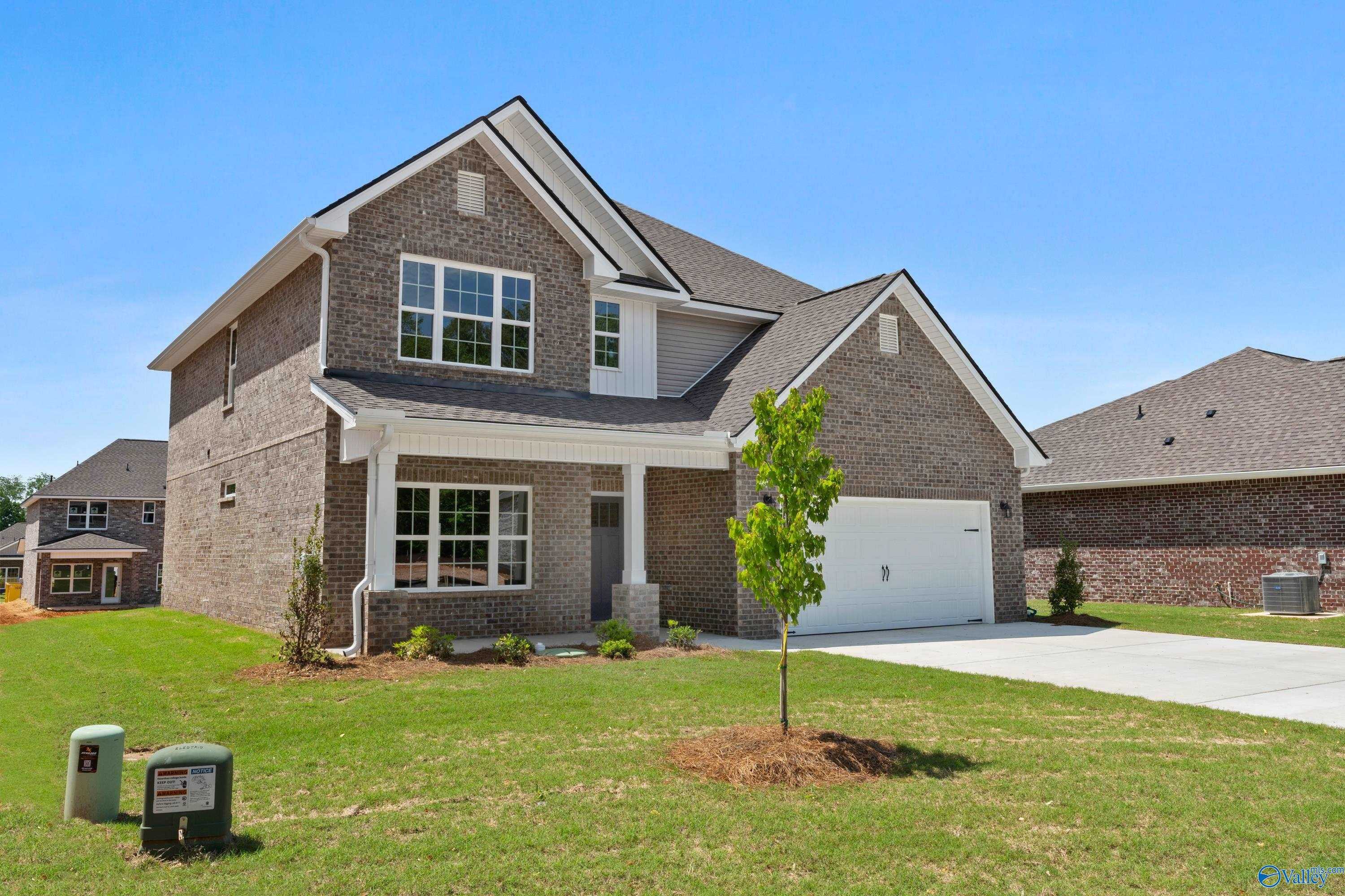 Two-story brick home with front porch, two-car garage, and lush lawn in Creek Grove, New Market, Alabama - Davidson Homes Chelsea B