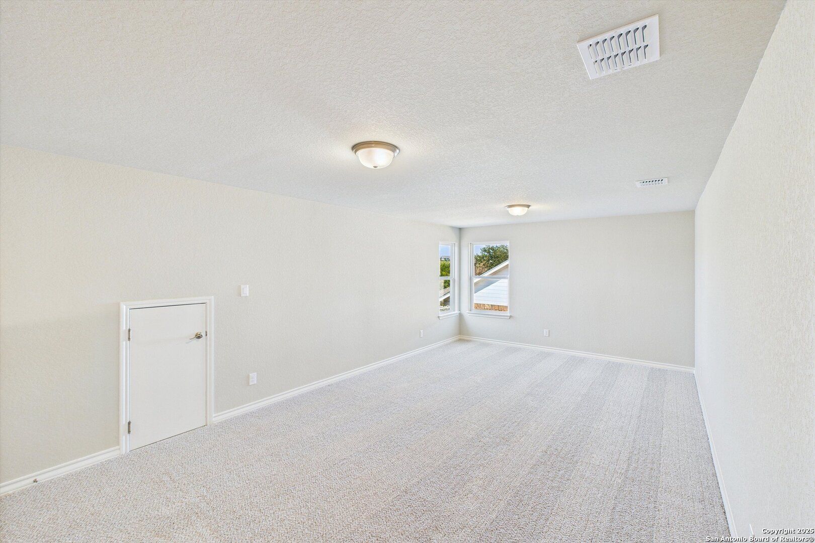 Empty bedroom with beige walls, berber carpet, recessed lighting, and window in 5-bedroom Davidson Homes The Jennings H, Ladera, San Antonio