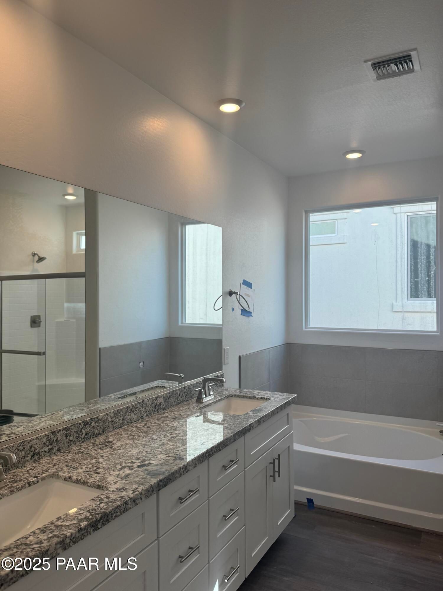 Elegant master bathroom featuring double granite vanity, soaking tub, and walk-in shower in Davidson Homes The Summit A, Prescott, Arizona