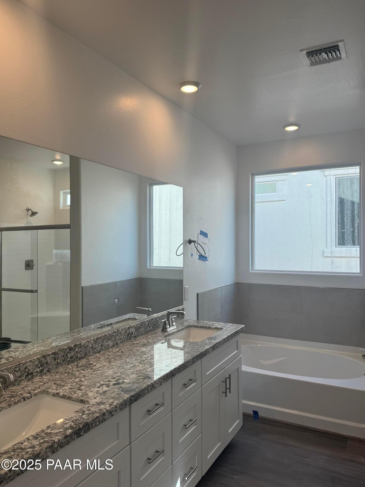 Elegant master bathroom featuring double granite vanity, soaking tub, and walk-in shower in Davidson Homes The Summit A, Prescott, Arizona