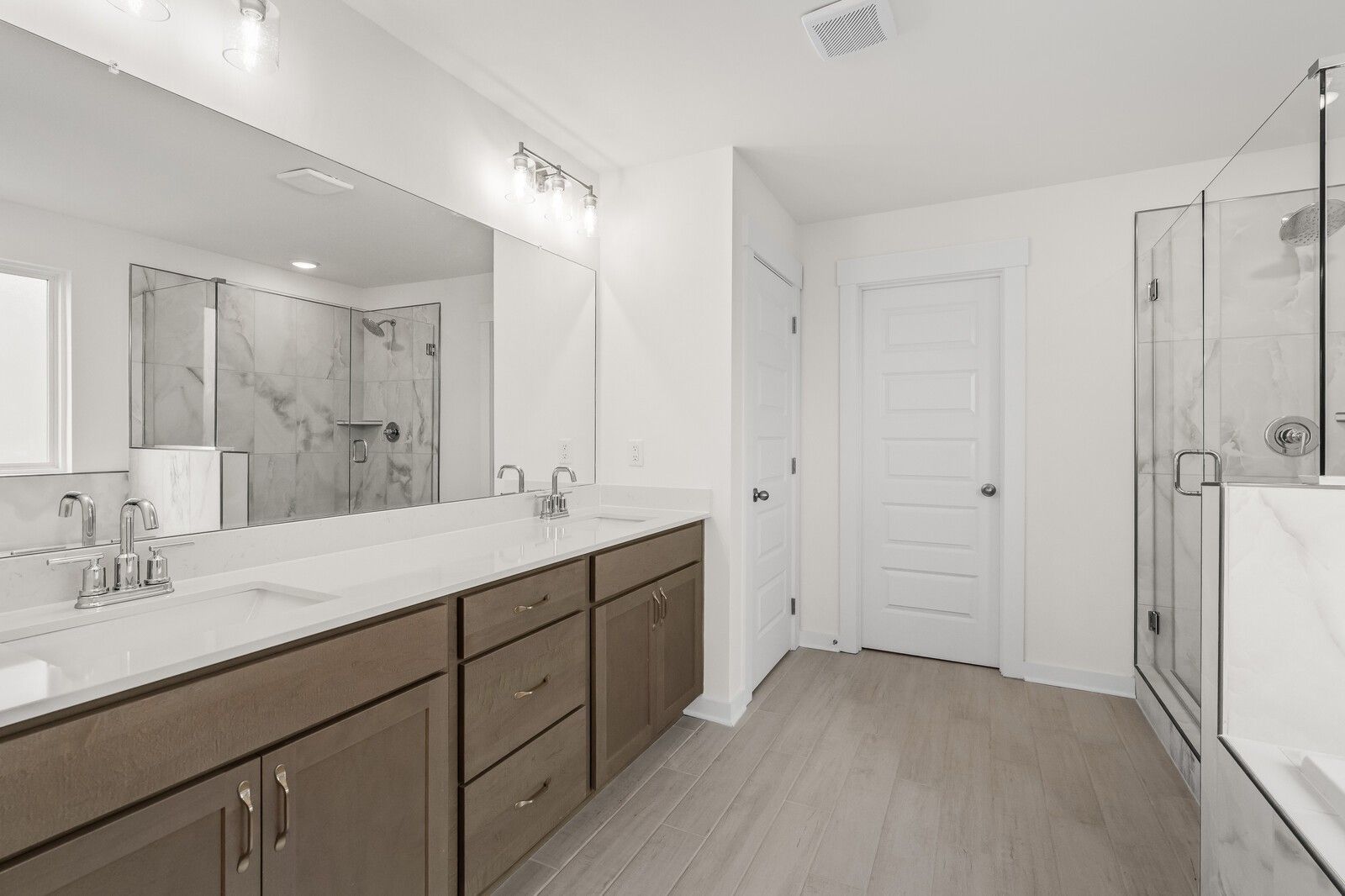 Modern primary bathroom with dual-sink vanity and glass-enclosed shower in The Henry C floor plan, Benders Cove, Mt. Juliet.