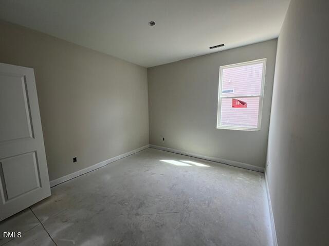 Empty bedroom with neutral beige walls, double doors, large window, and hardwood floors in Davidson Homes Preston A, Lillington, NC