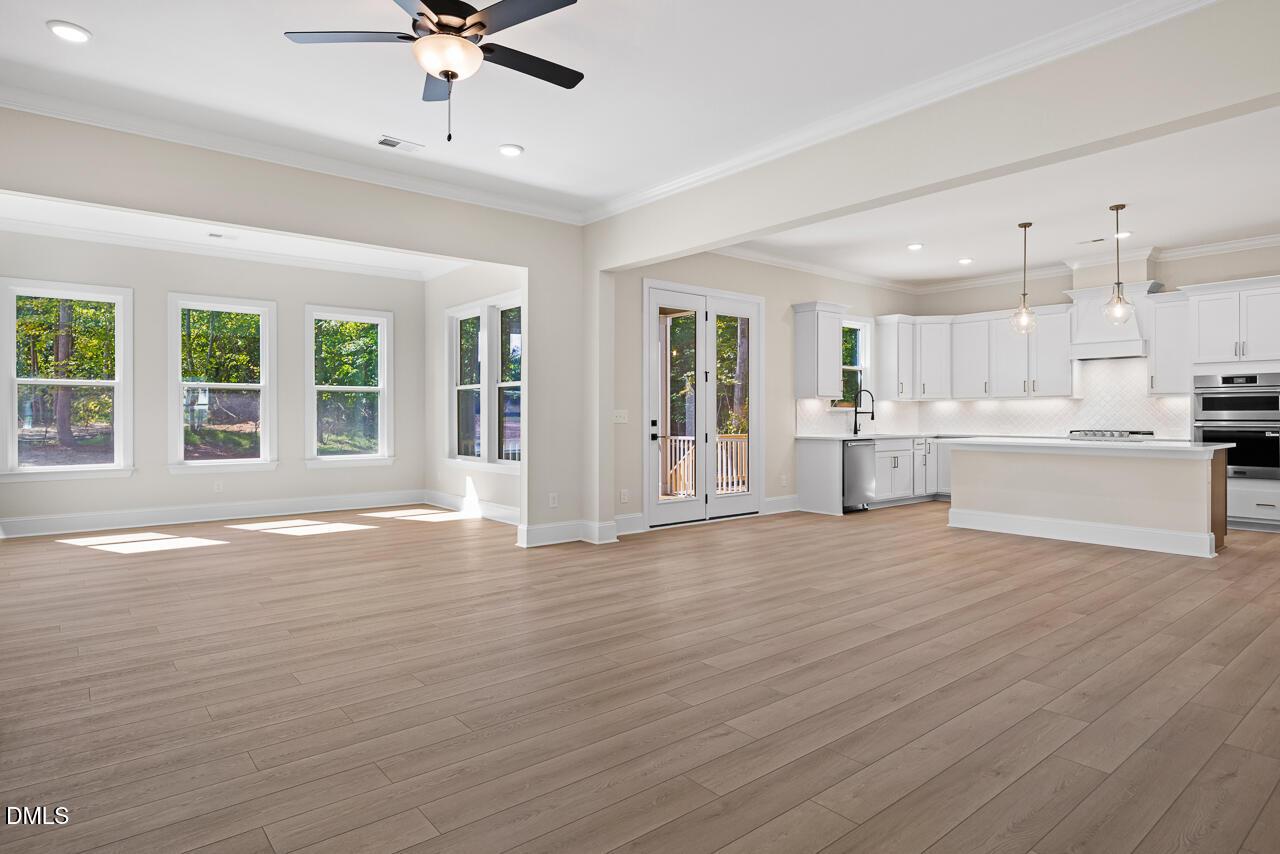 Open-concept living room and white kitchen with island in Davidson Homes The Crawford D plan, Wake Forest, North Carolina