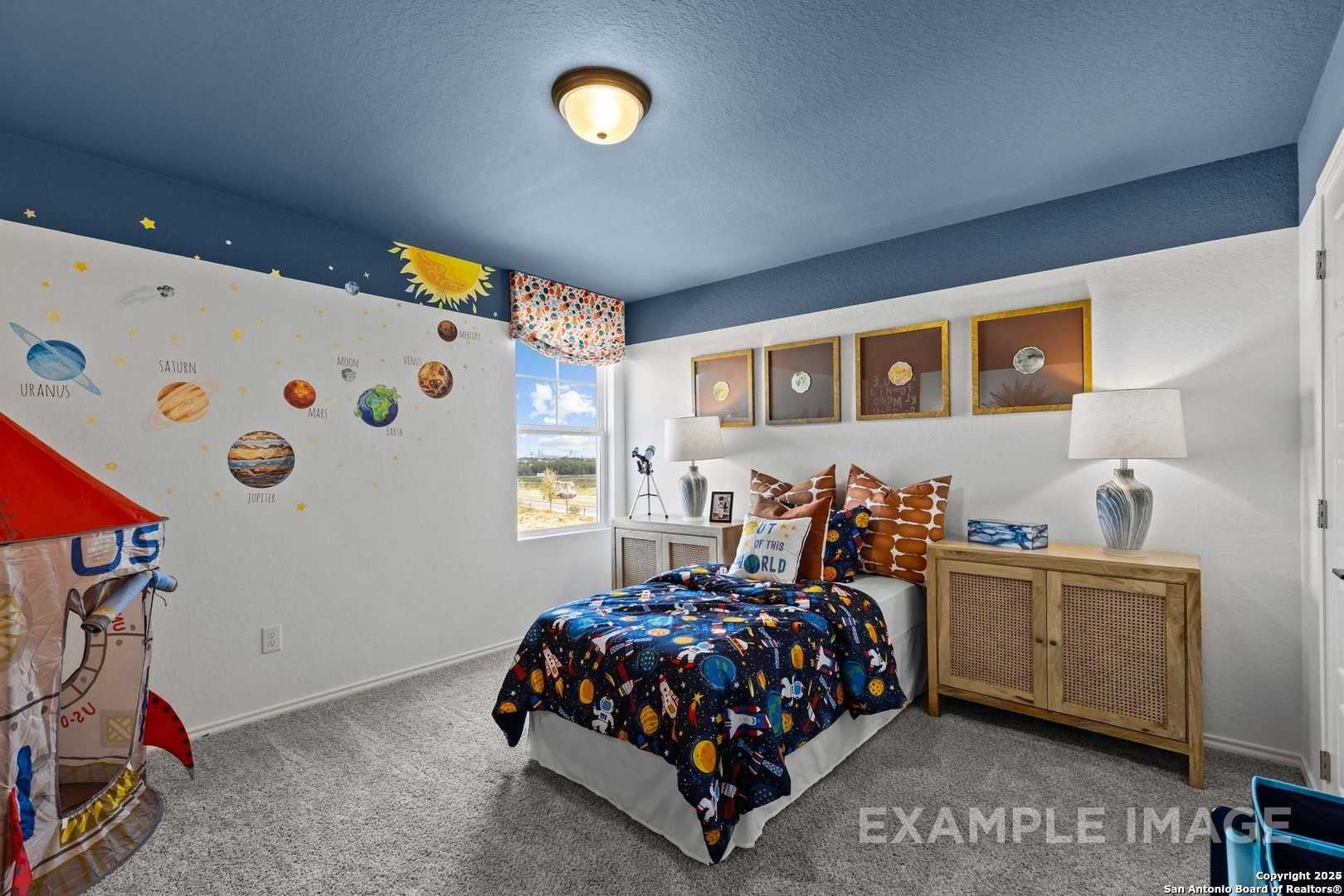 Space-themed kids' bedroom with rocket decals, planet murals, blue ceiling, and twin bed in Davidson Homes The Douglas C, Seguin, Texas