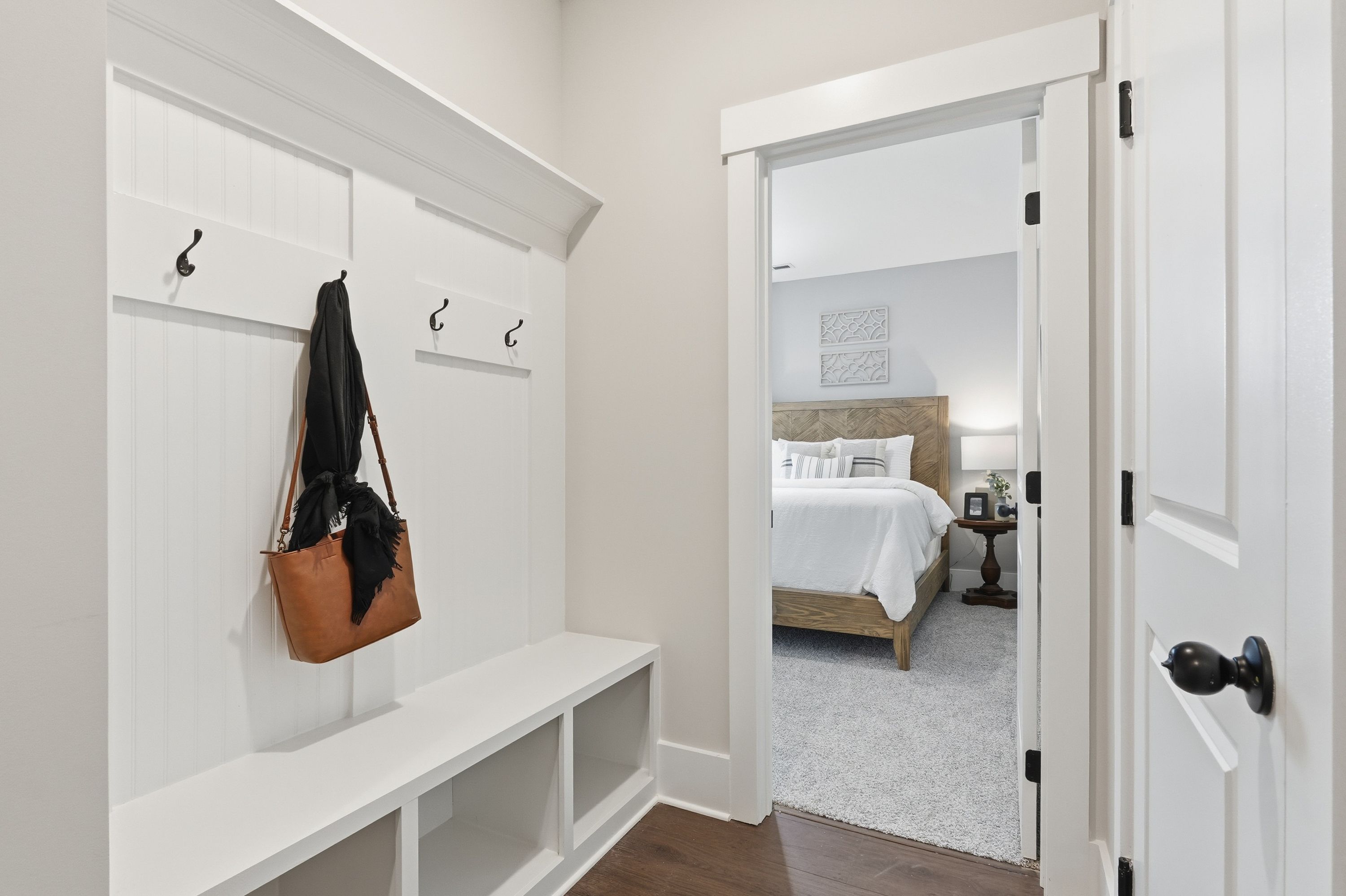 White shiplap mudroom with coat hooks bench and purse at Noble Ridge in Cullman Alabama