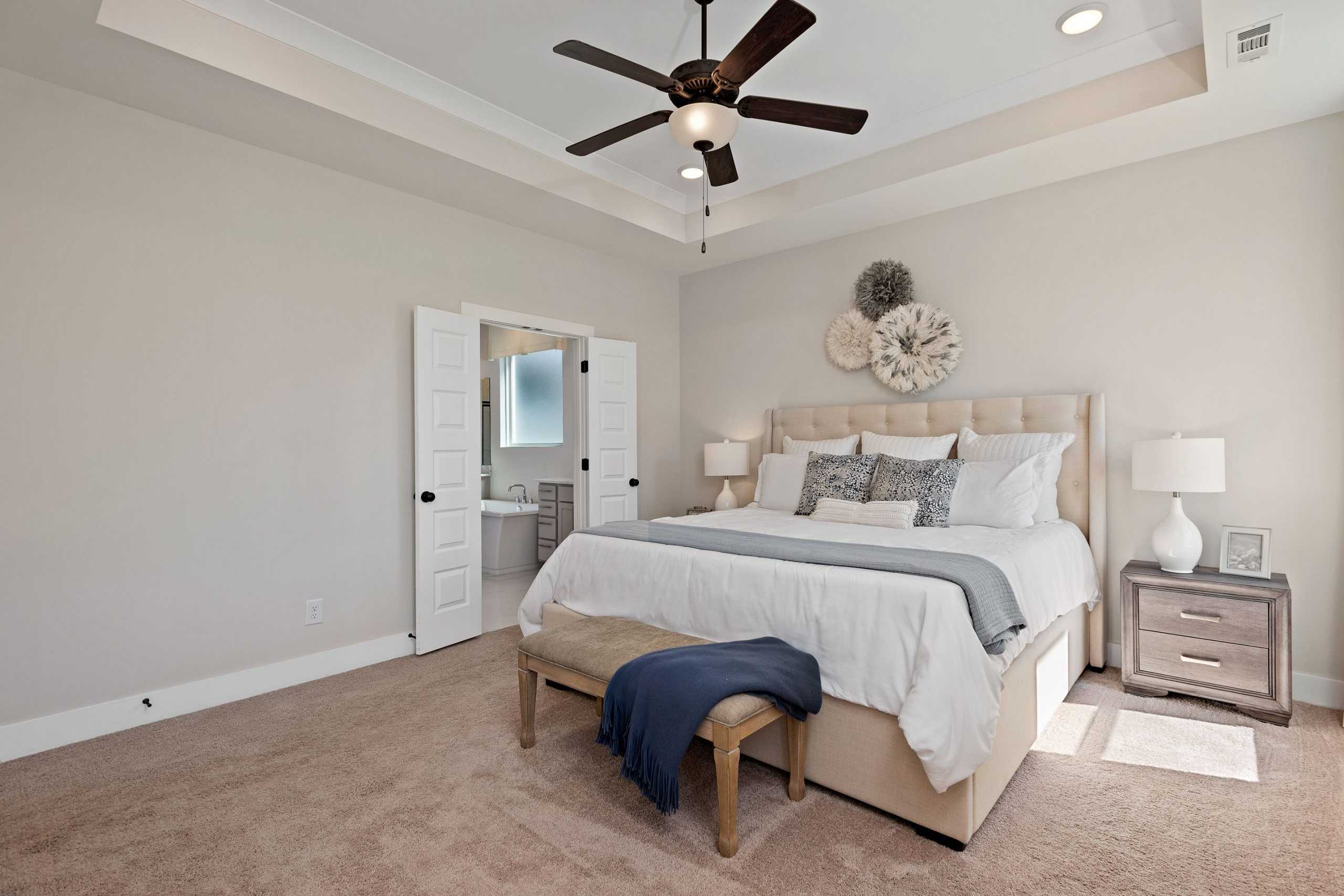 Master bedroom suite at Rivers Edge in Murfreesboro TN with upholstered king bed, ceiling fan, and en-suite bath