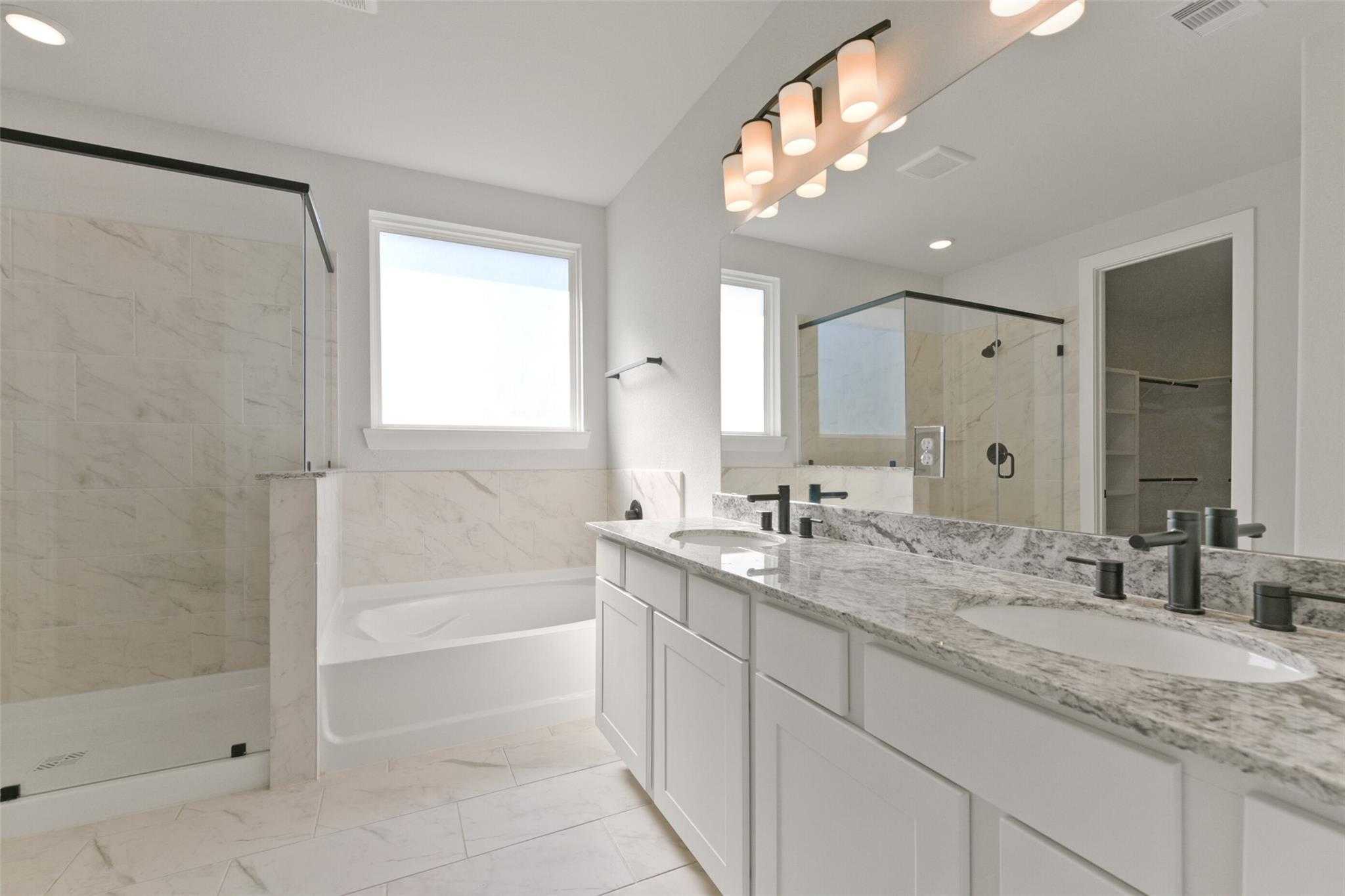 Elegant master bathroom with double vanity, freestanding tub, walk-in shower in Davidson Homes The Edward C, Lago Mar, Texas City