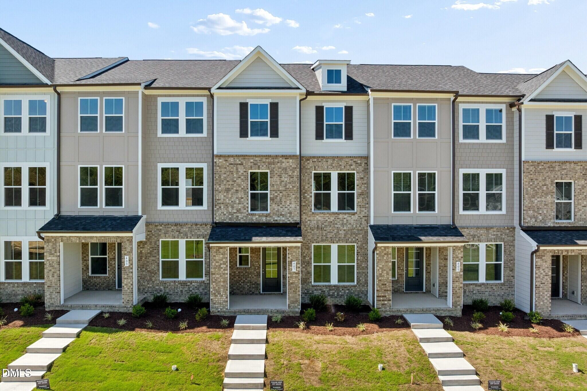 Modern brick townhome exteriors with covered porches at Forestville Yard Townhomes by Davidson Homes in Knightdale, North Carolina