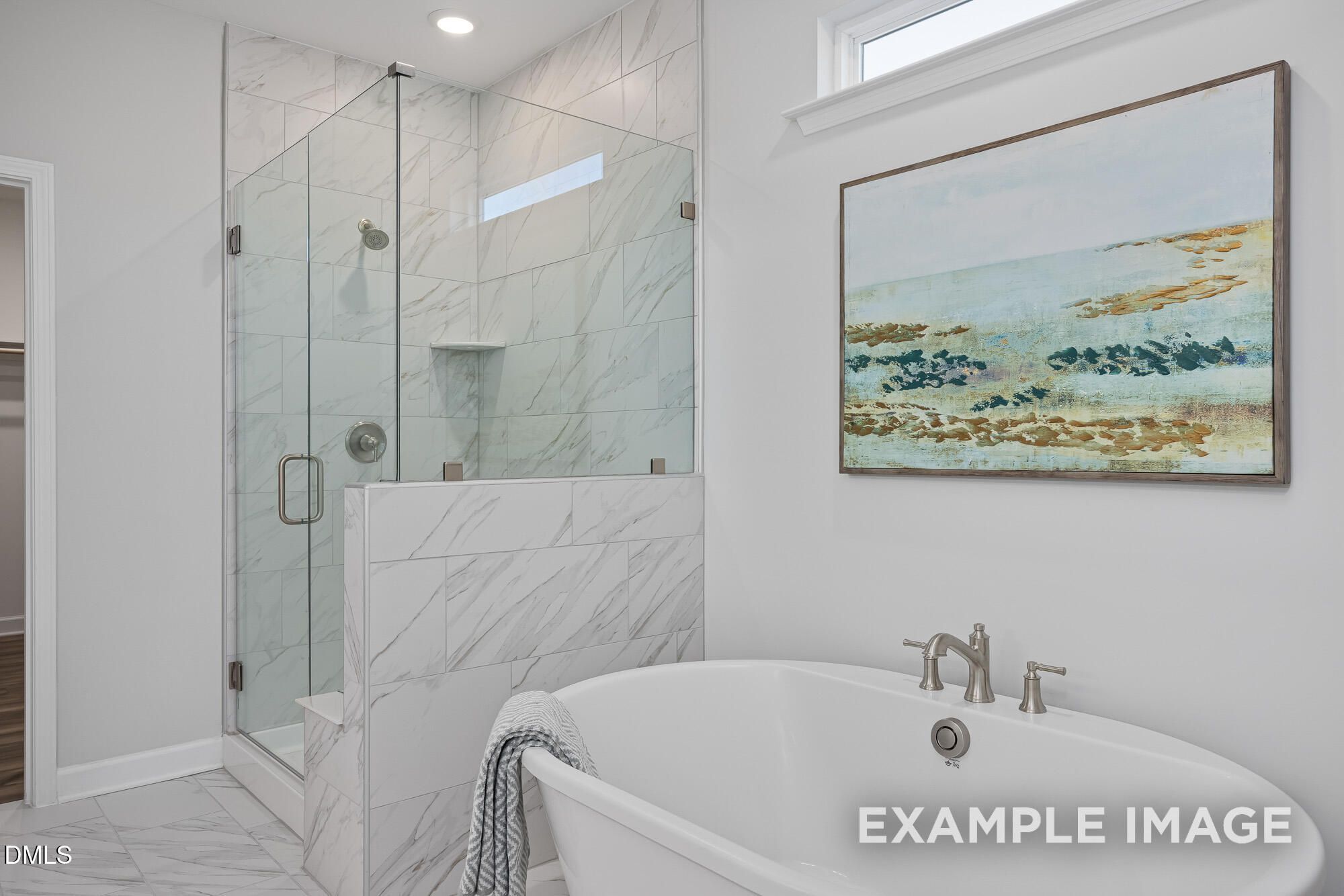 Luxurious master bathroom featuring freestanding tub, glass shower, and marble tiles in Davidson Homes The Cypress B II, Angier, NC