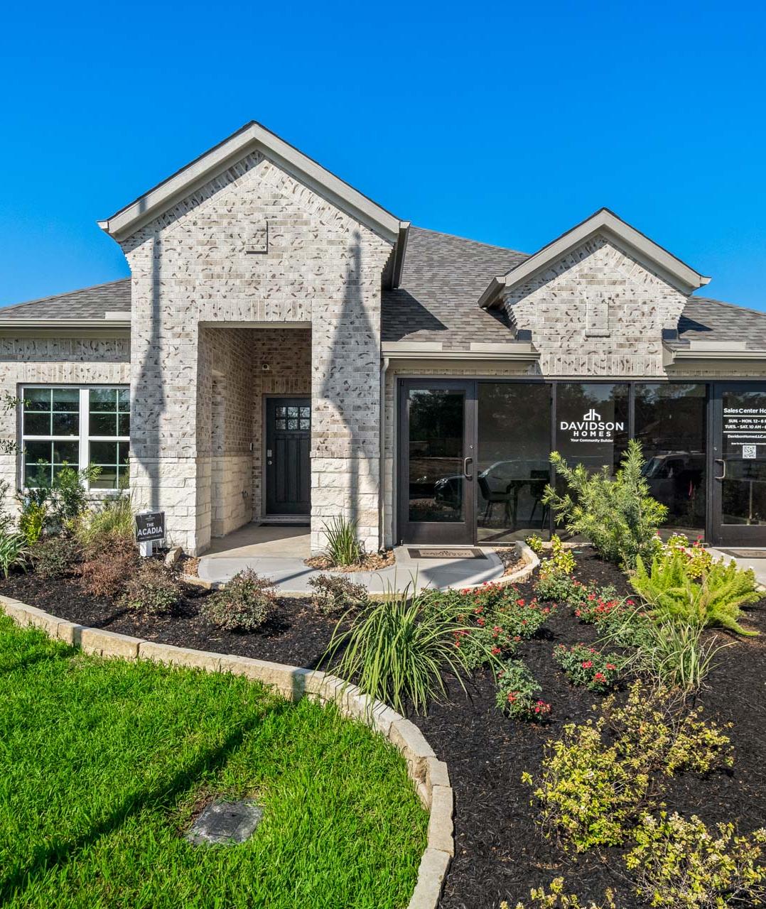 Spacious modern kitchen at Windmill Estates in Magnolia Texas with taupe cabinets, granite island, stainless steel appliances, hardwood floors