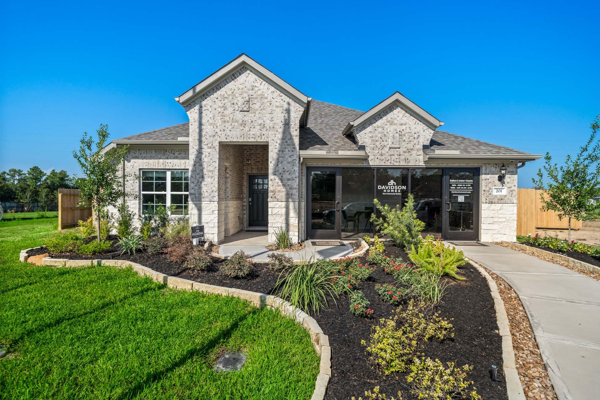 Modern brick home exterior at Windmill Estates in Magnolia Texas with gabled roof, large windows, and landscaped pathway