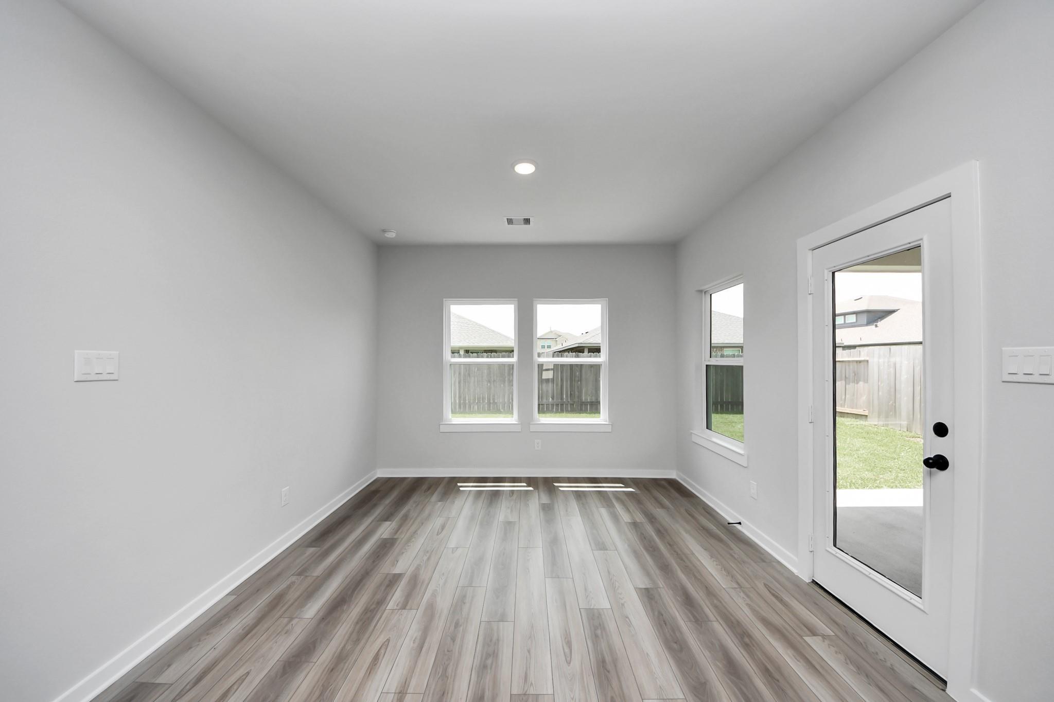 Bright, spacious breakfast nook with wood-look flooring in The Everett C floor plan at River Ranch Meadows, Dayton, Texas.