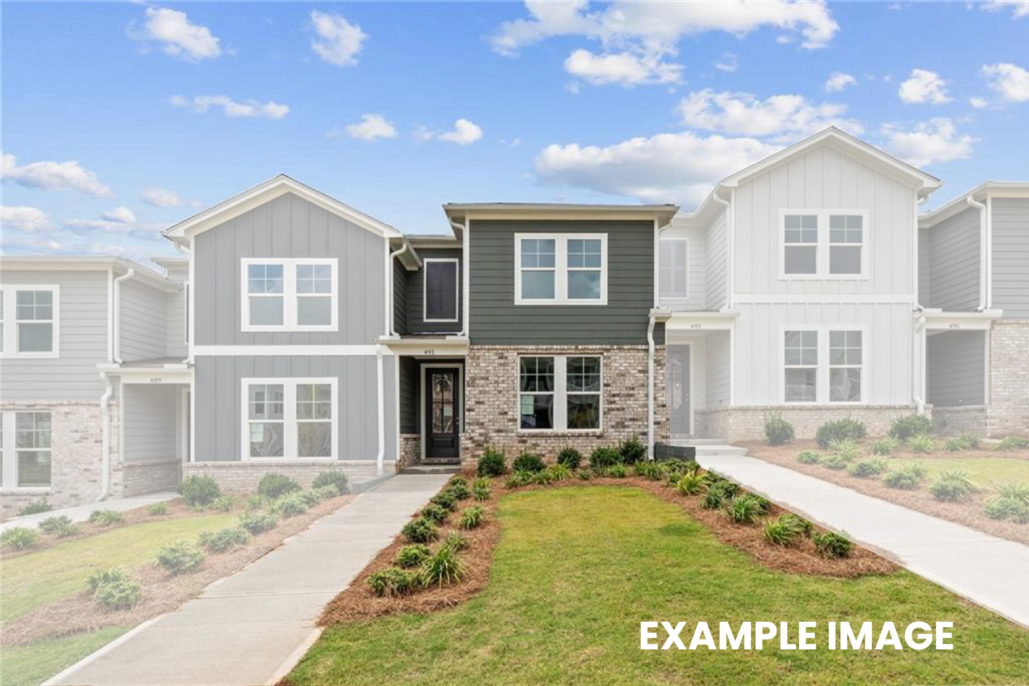 Modern 2-story townhome exterior with green siding, stone accents, garage, and landscaped walkway in Stegall Village, Emerson, Georgia - Davidson Homes The Monroe A
