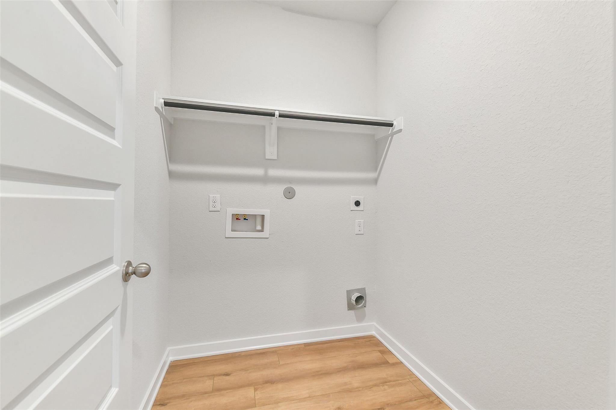 Spacious laundry room with washer-dryer hookups, storage closet and laminate flooring in Davidson Homes The Blanco E, Magnolia TX