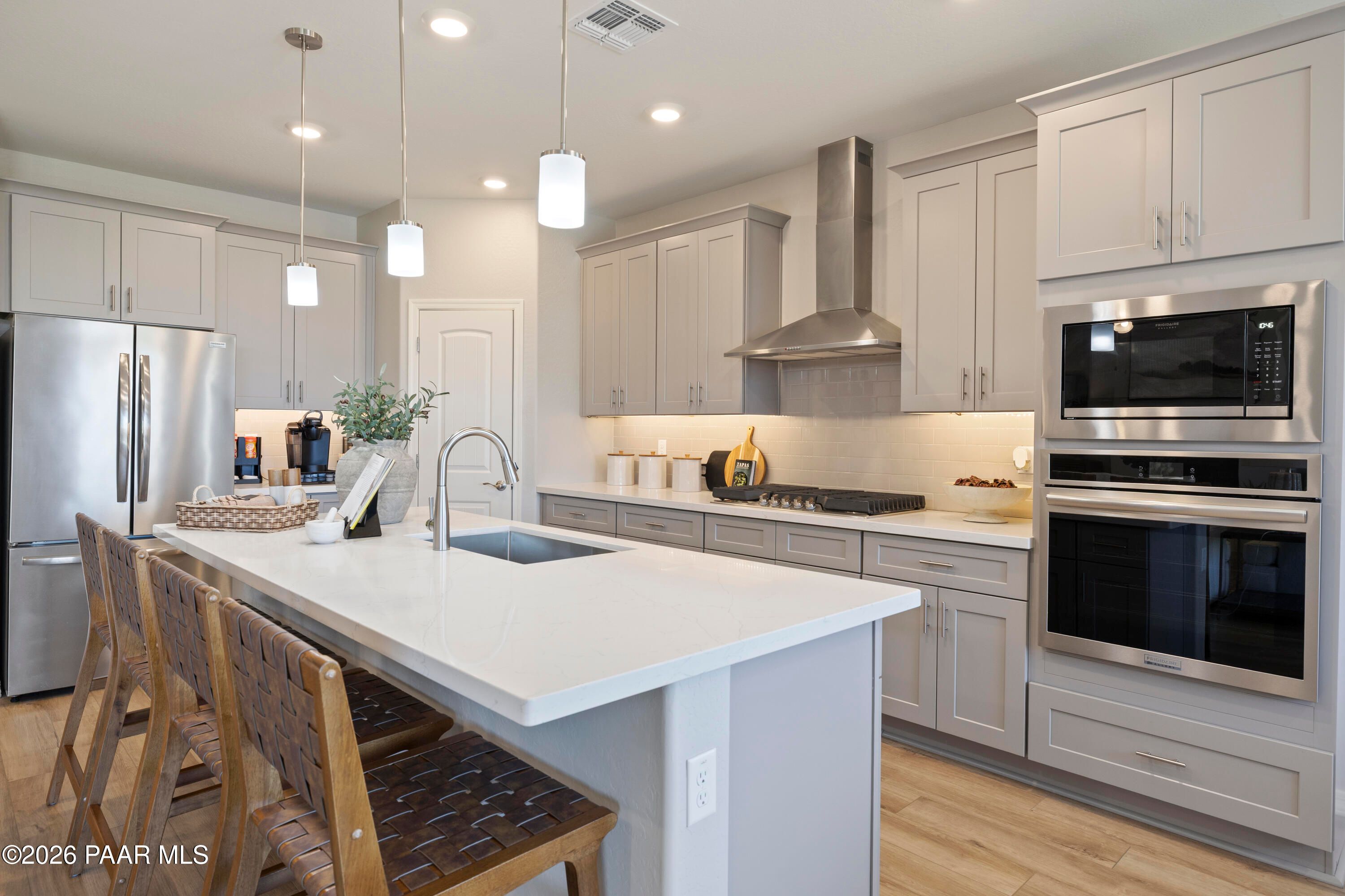 Modern kitchen with quartz island, gray cabinets, stainless appliances in Davidson Homes The Harmony A, Prescott Valley, AZ