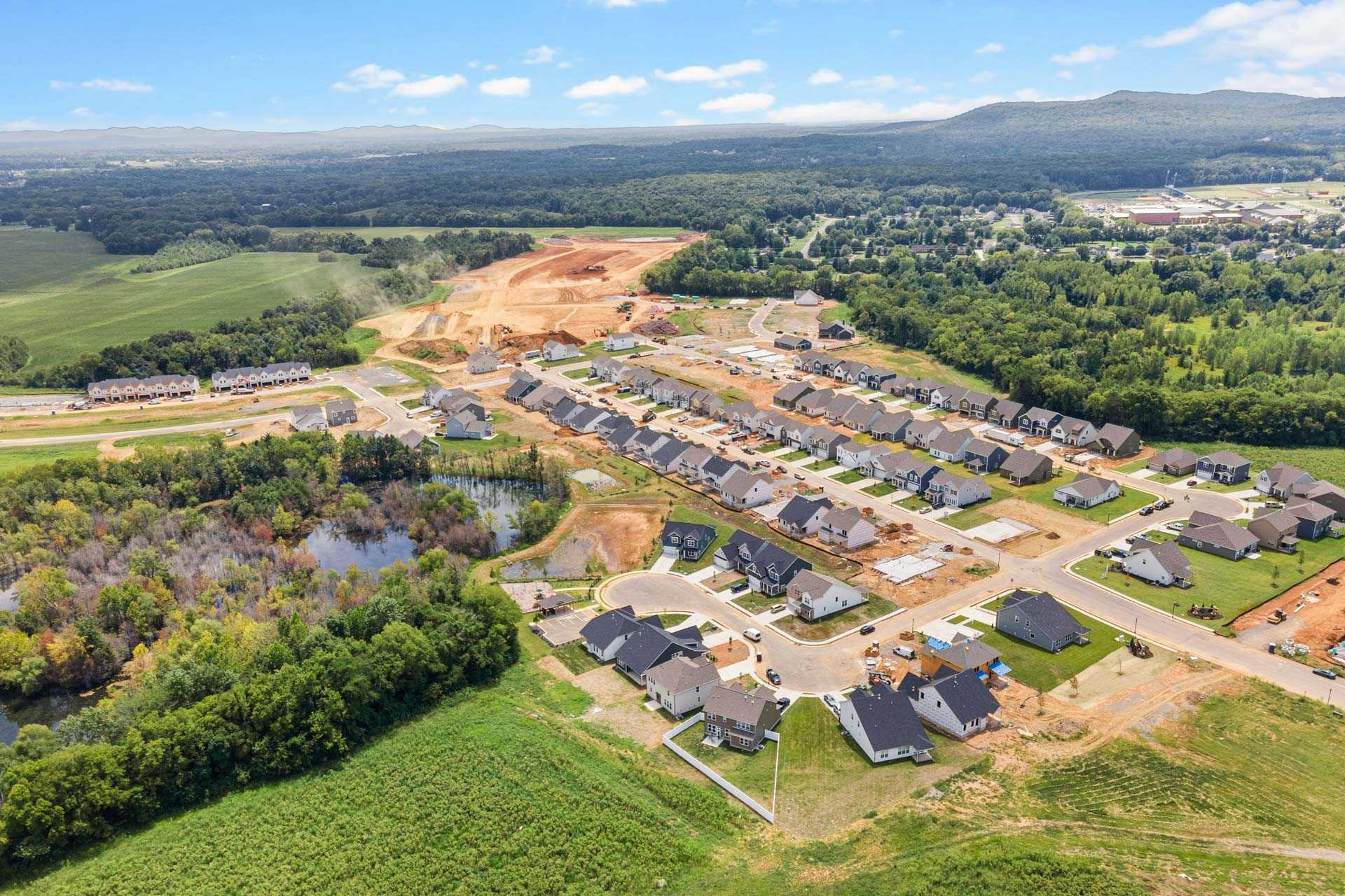Aerial view of Salem Landing new homes in Murfreesboro TN with construction sites, wooded surroundings, and green fields