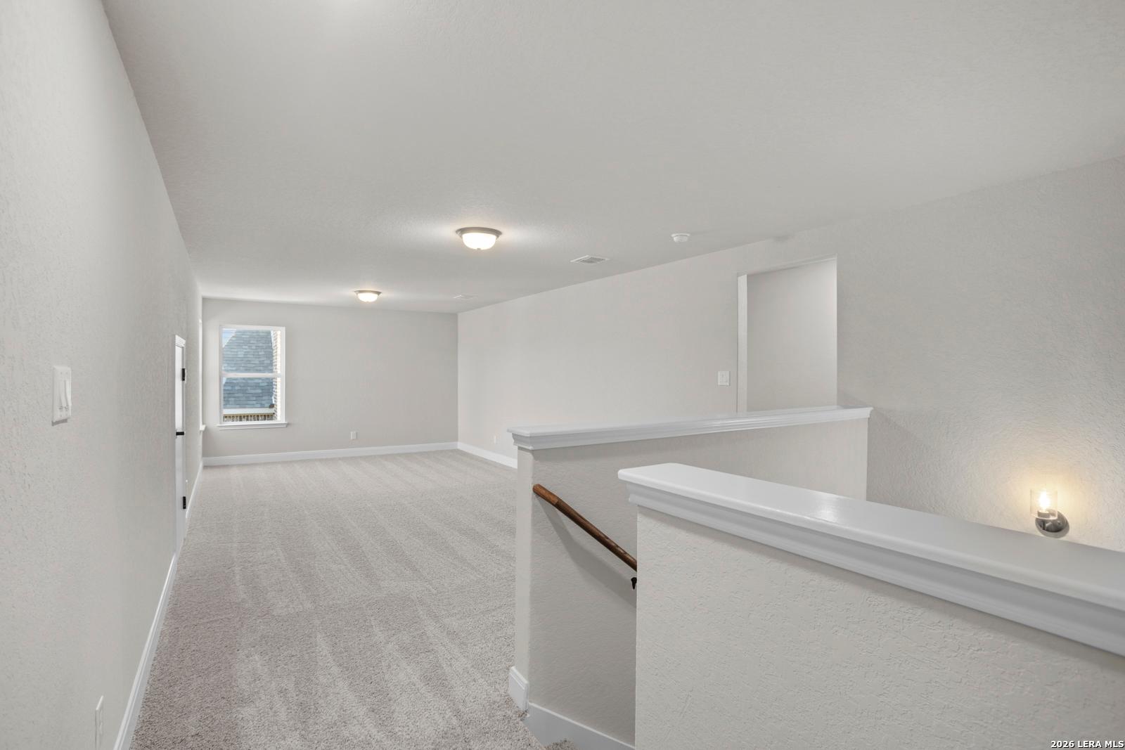 Spacious carpeted loft area in The Jennings G floor plan by Davidson Homes in Ladera, San Antonio, Texas.