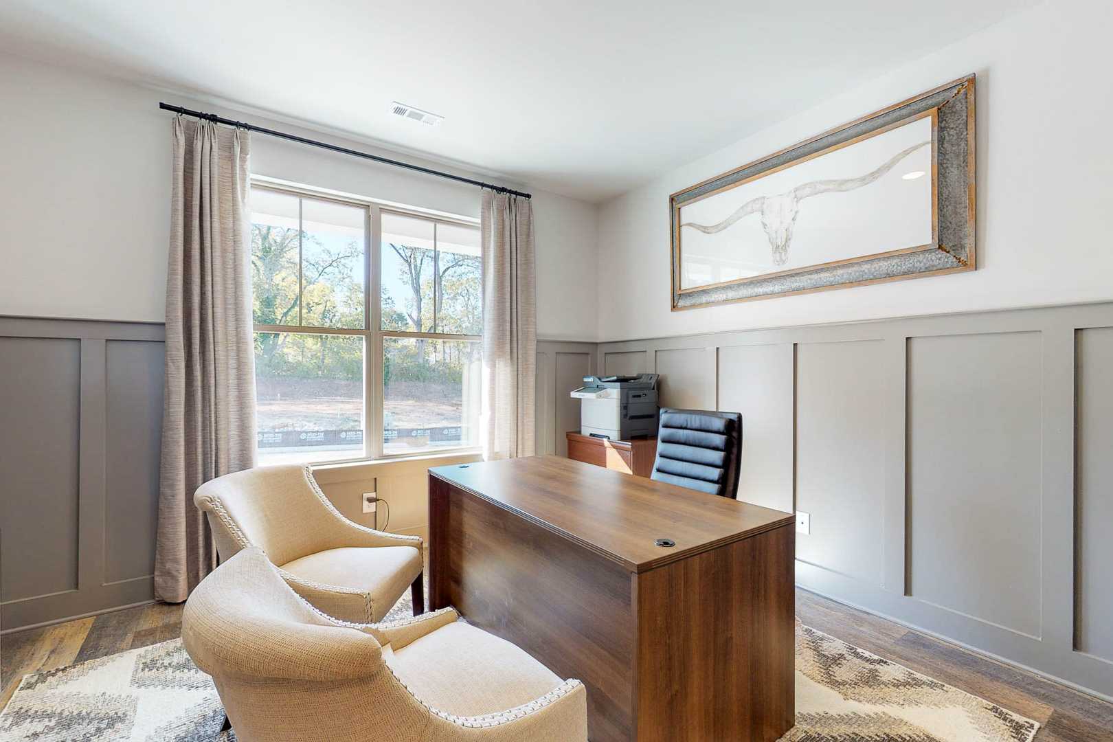 Cozy home office in Liberty Creek Gallatin TN with wooden executive desk, gray shiplap walls, beige armchairs and tree-view window