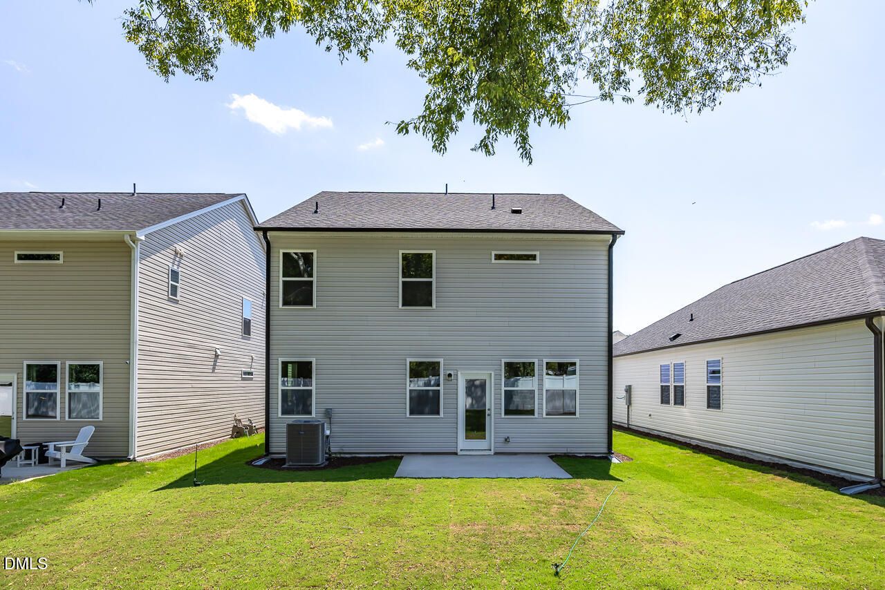 Rear exterior view of The Gavin A floor plan by Davidson Homes featuring a concrete patio in Gregory Village, Lillington, NC.