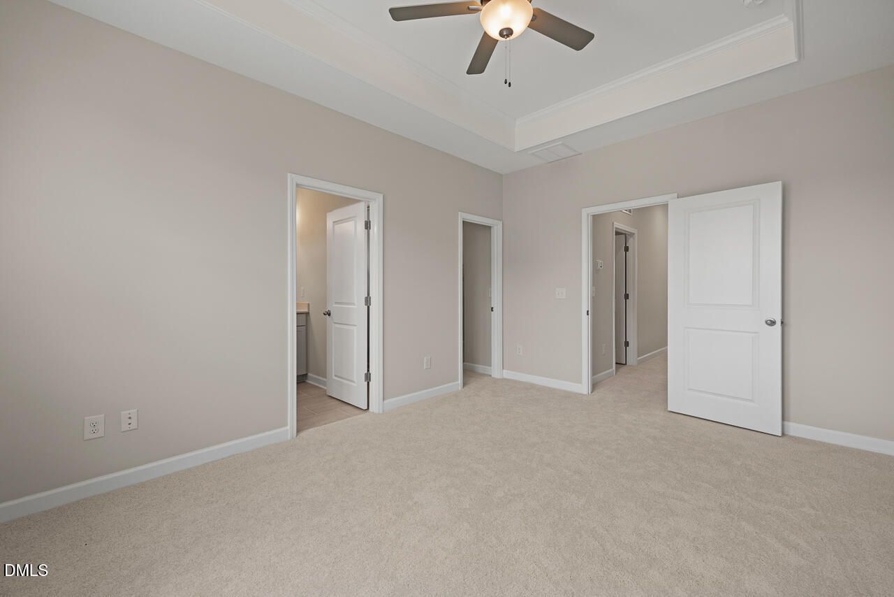 Spacious bedroom with tray ceiling and ceiling fan in The Alexander C floor plan at Forestville Yard, Knightdale, NC.
