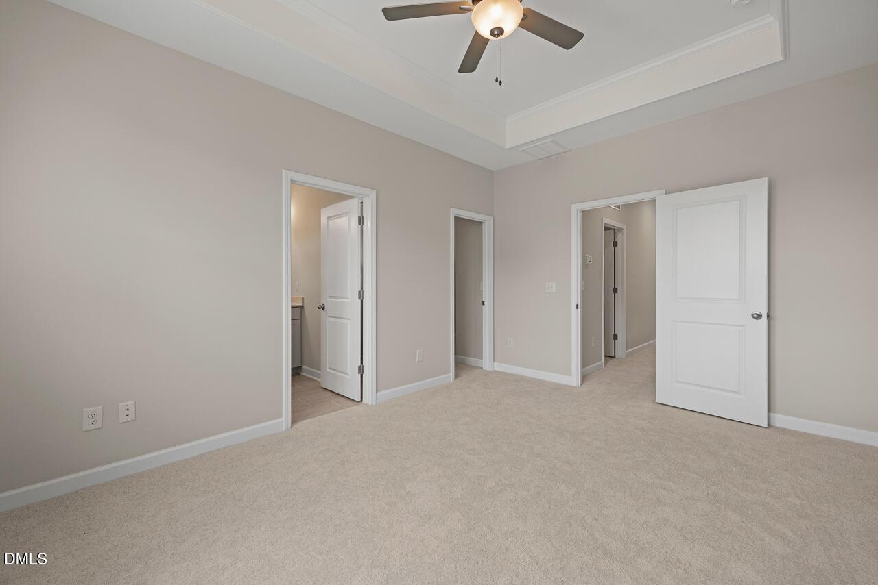 Spacious bedroom with tray ceiling and ceiling fan in The Alexander C floor plan at Forestville Yard, Knightdale, NC.