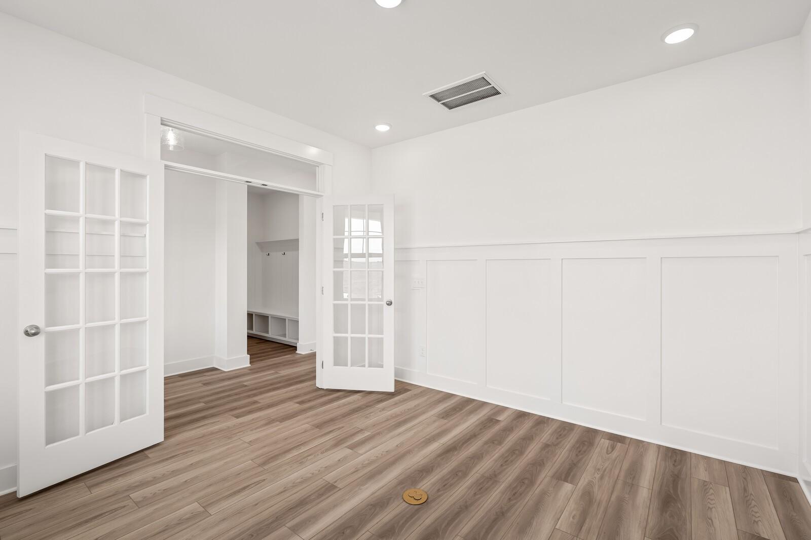 Bright hallway with open French doors, white wainscoting, hardwood floors in Davidson Homes The Ash C, Mt. Juliet, TN