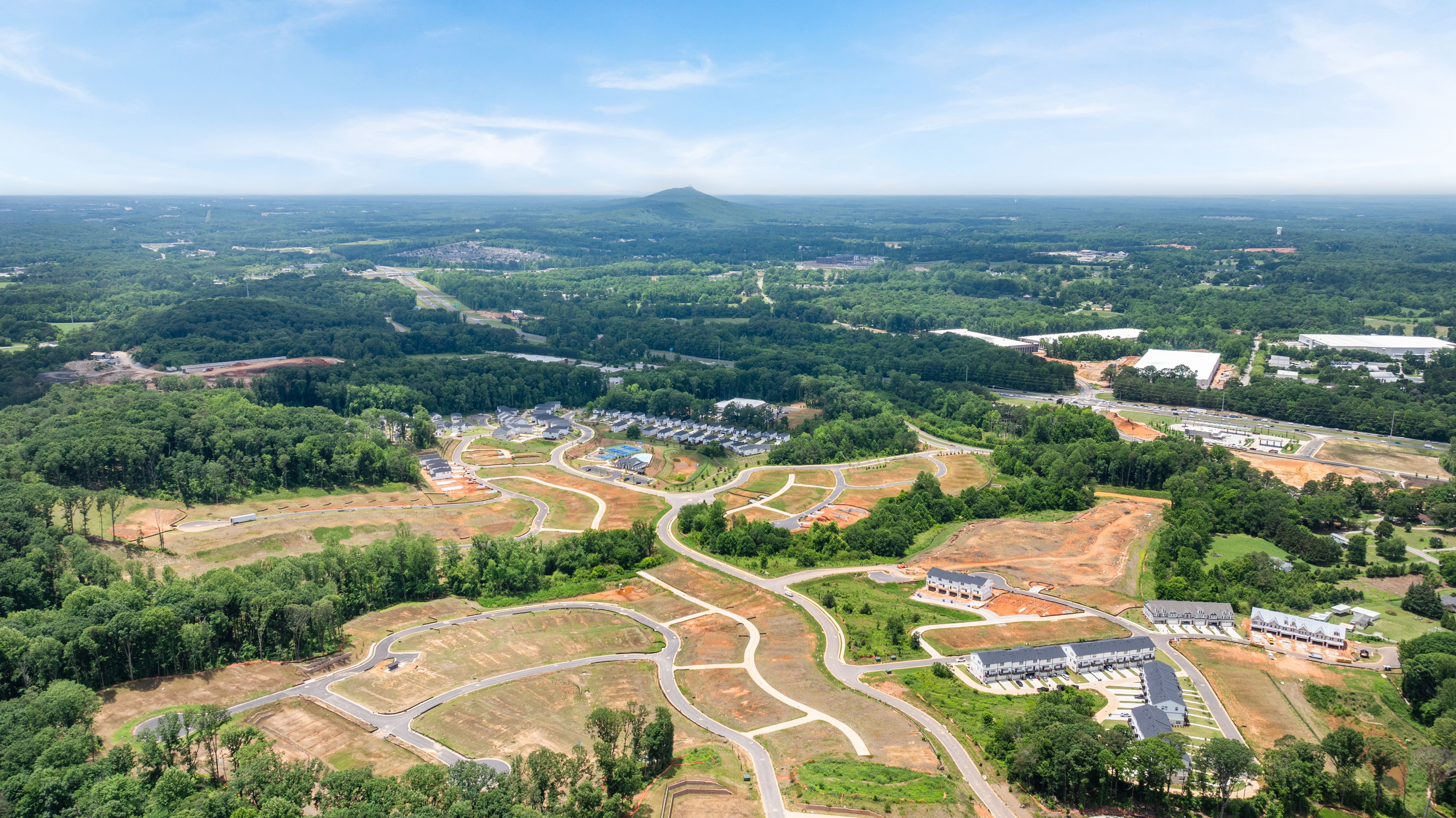 Aerial view of Hemingway community construction site in Cumming, GA by Davidson Homes with surrounding wooded landscape.