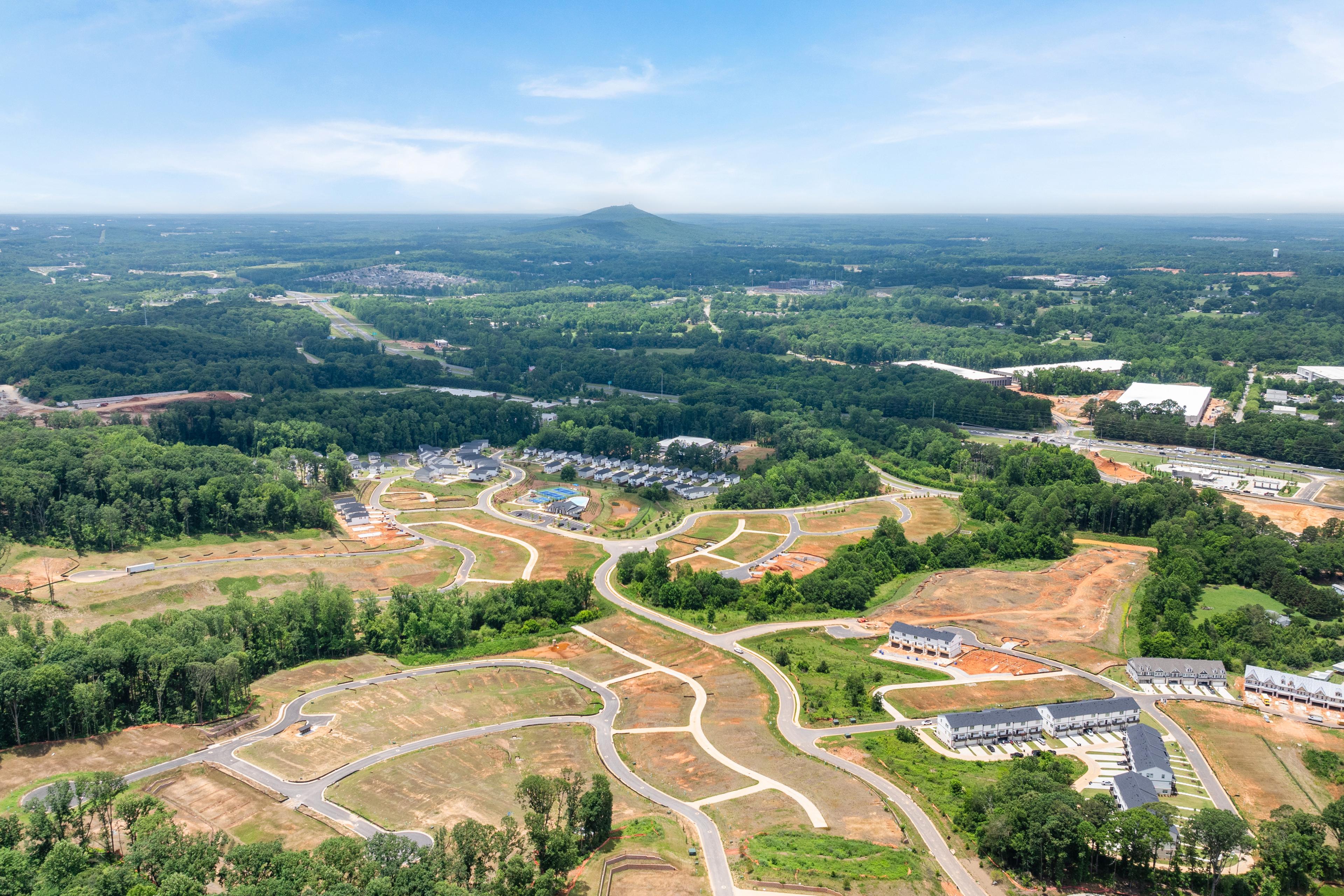 Aerial view of Hemingway community construction site in Cumming, GA by Davidson Homes with surrounding wooded landscape.