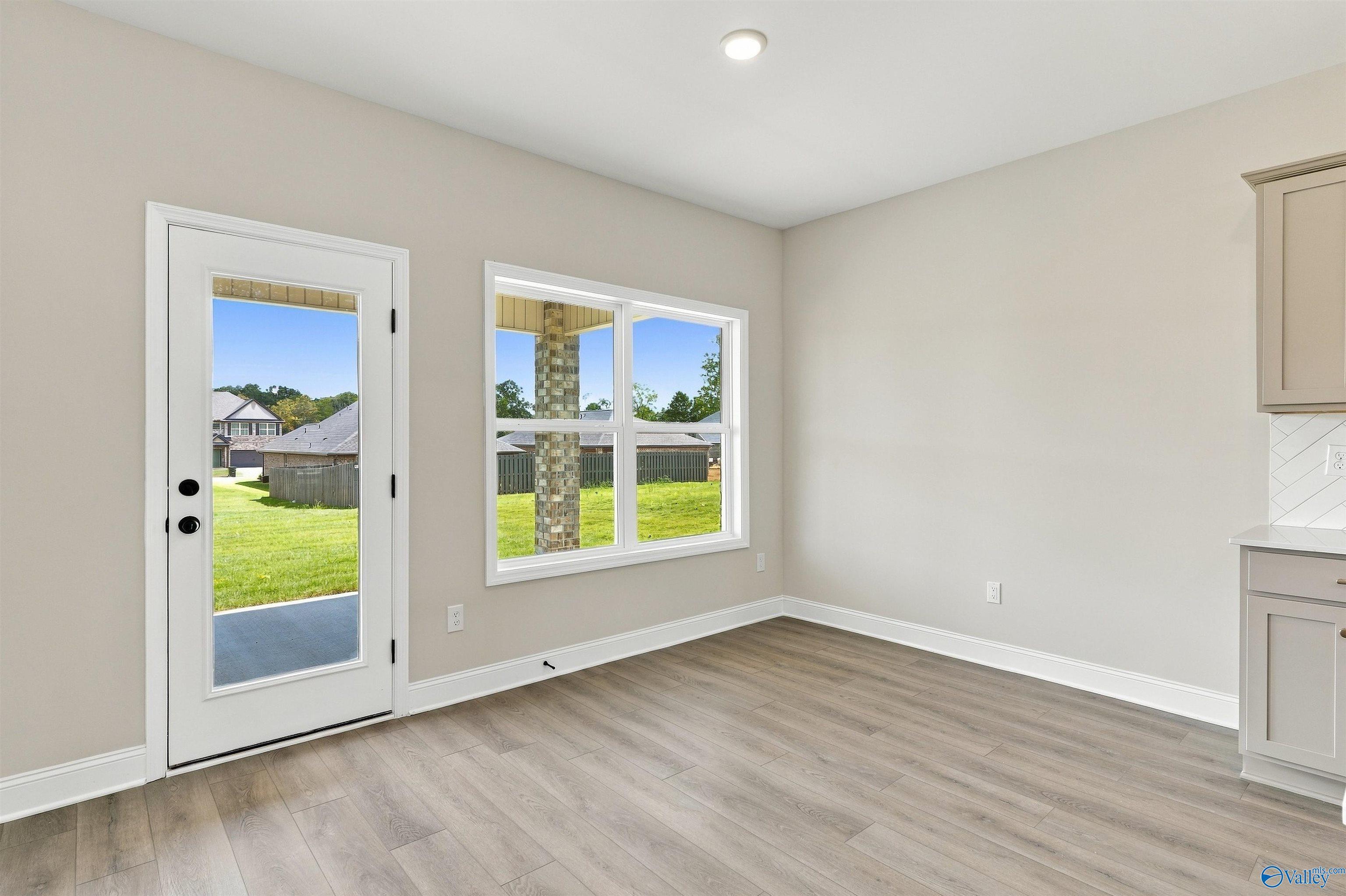 Bright dining area with glass back door and picture window overlooking fenced backyard in Davidson Homes The Shelby A, Athens, AL