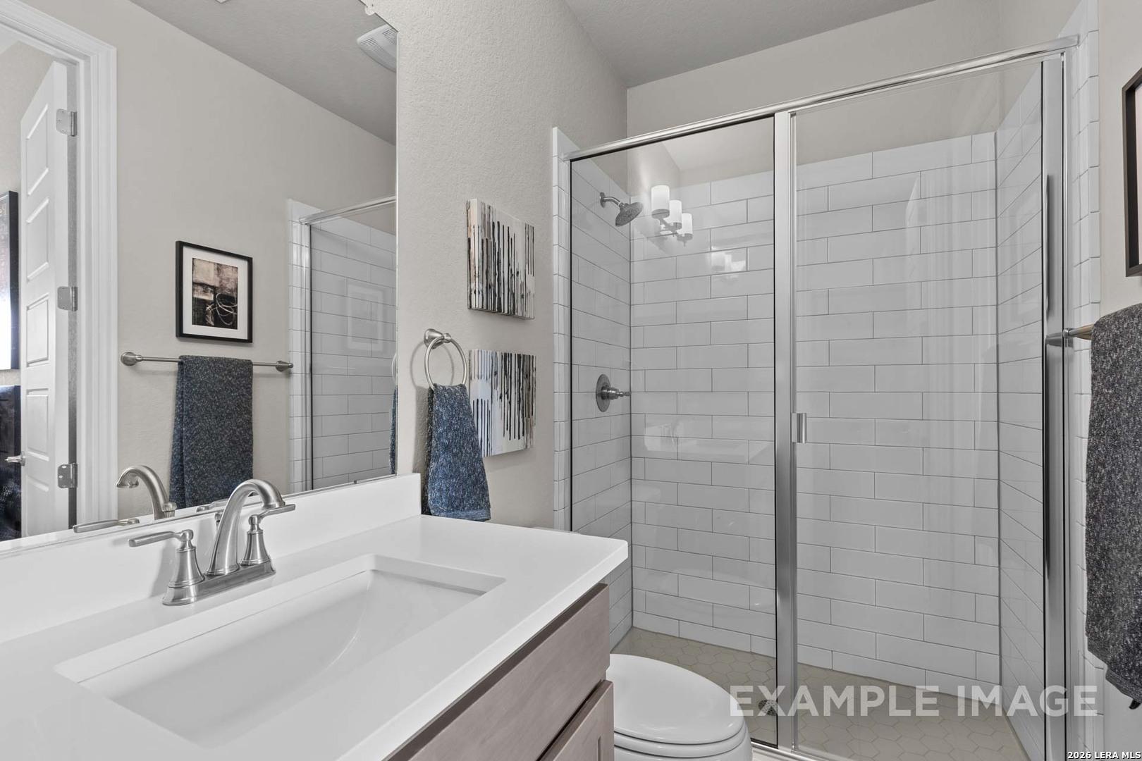Modern bathroom with white subway tile shower and vanity in The Garner C floor plan at The Reserve at Potranco Oaks.